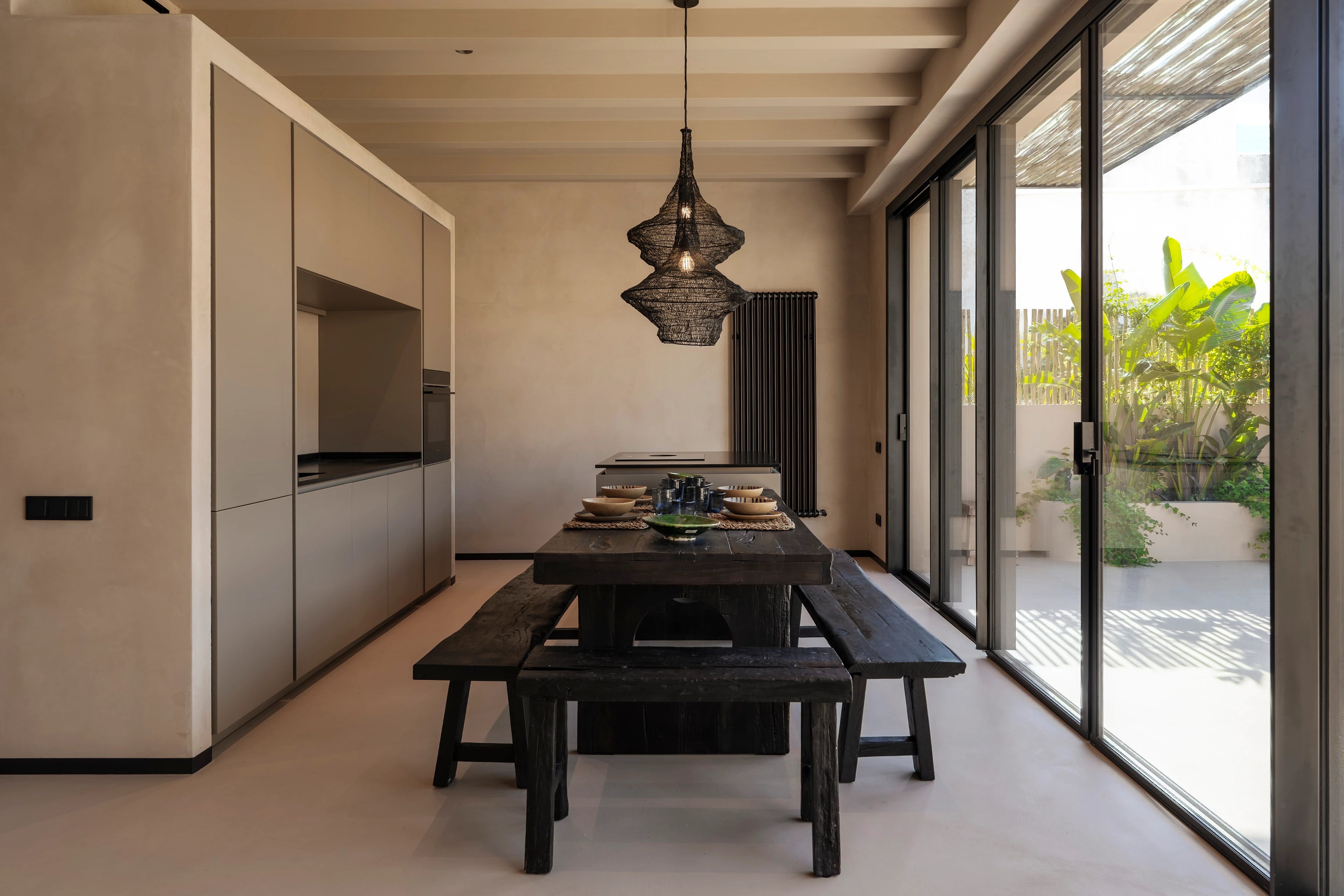 Modern interior. Living room with large window, gray sofa, geometric rug, wooden coffee table. Abundant natural light.