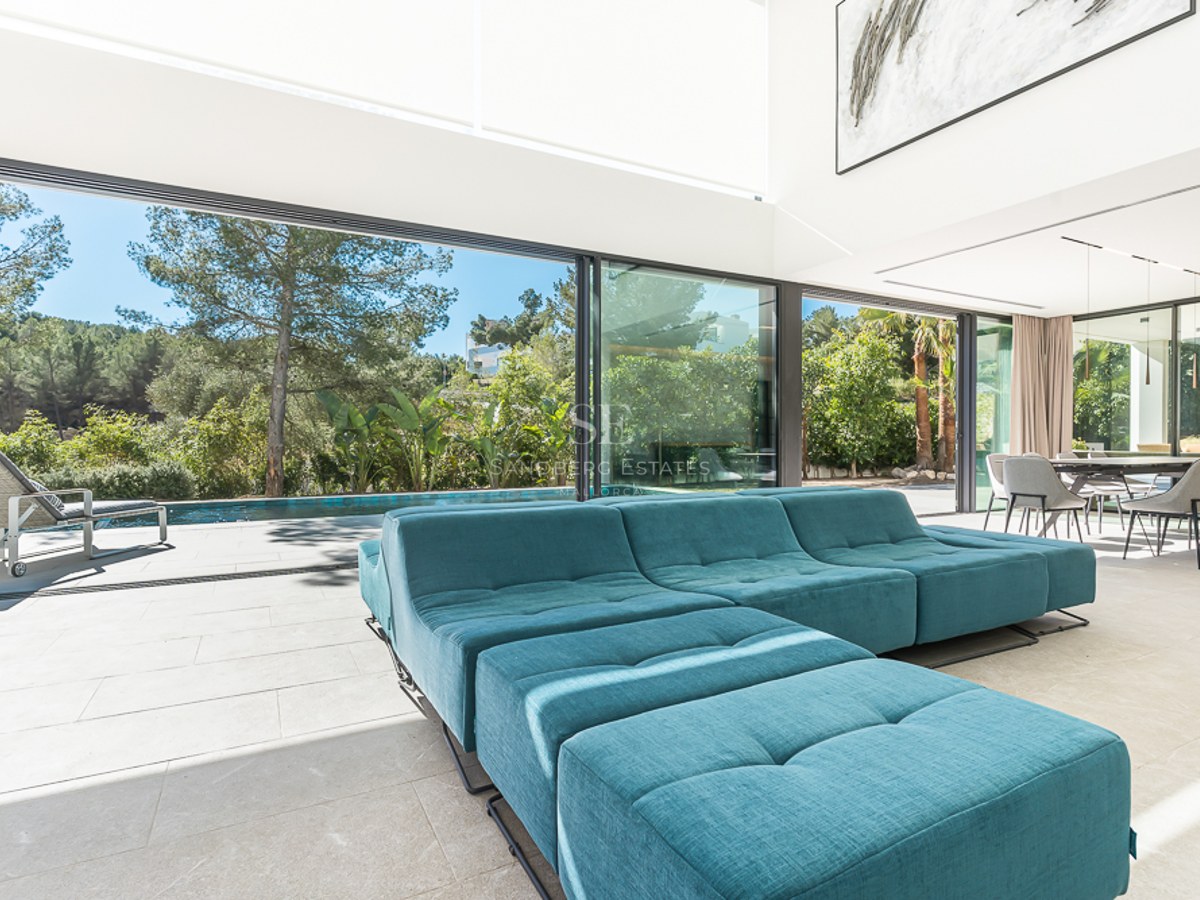 Flygfoto av modern villa med infinitypool, välskött trädgård, rymliga terrasser och minimalistisk arkitektur. Detaljer om landskapsarkitektur och exteriör design.