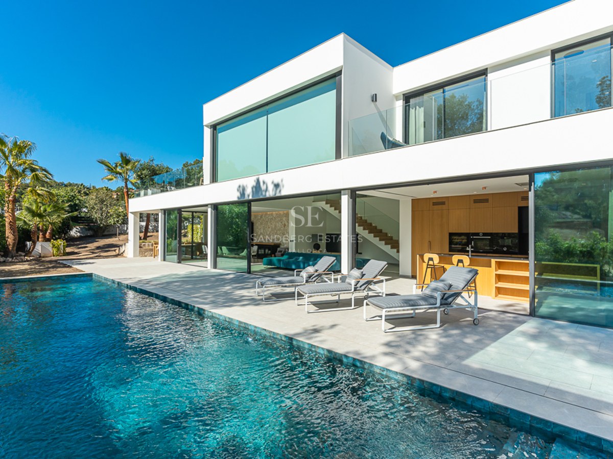 Exteriör av modern villa med pool, gräsmatta och stora fönsterpartier. Minimalistisk design med rena linjer och rikligt med naturligt ljus.