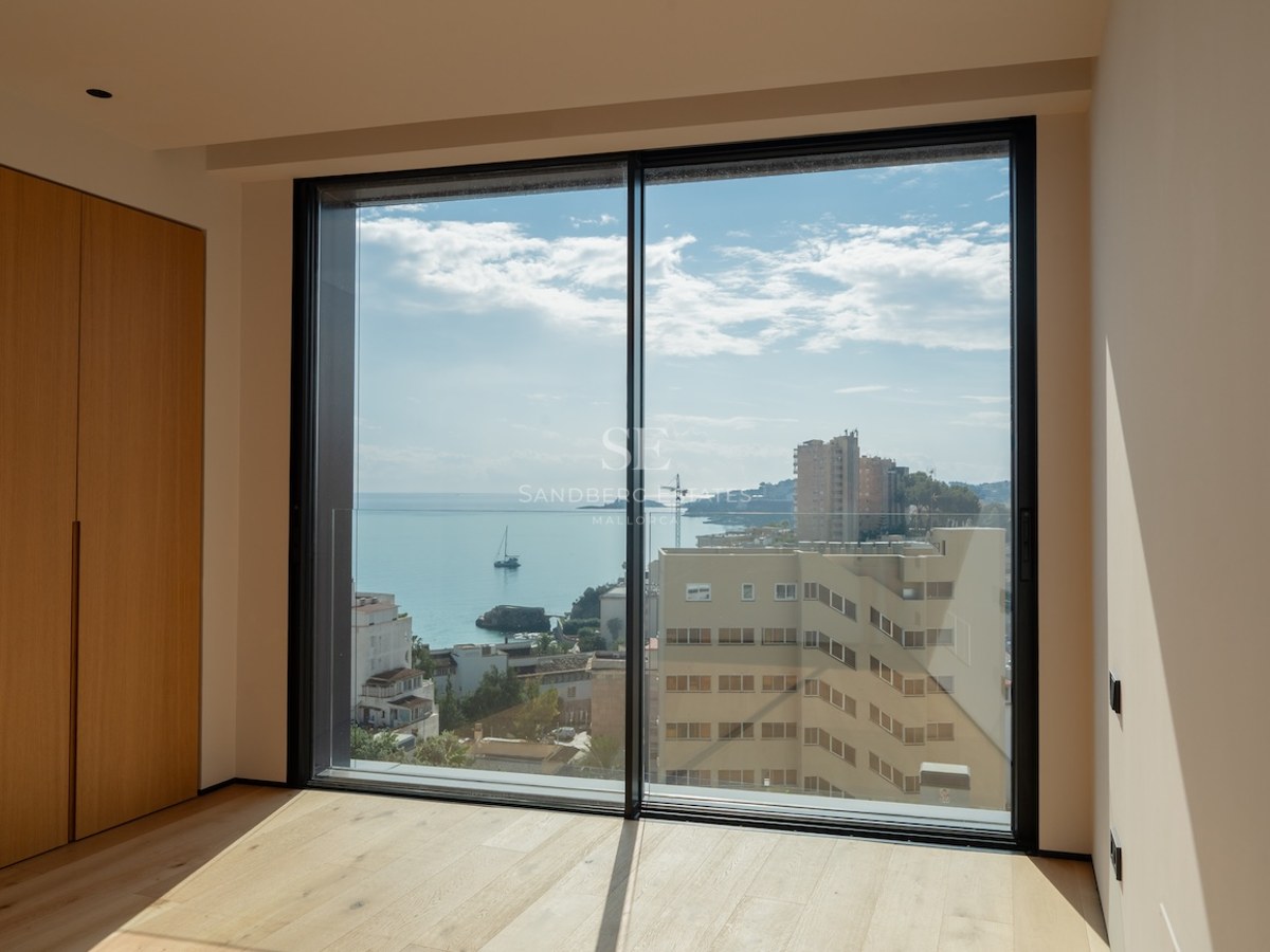 Minimalistisches Schlafzimmer mit Eichenparkett und bodentiefe Fenster mit Blick auf das Mittelmeer.