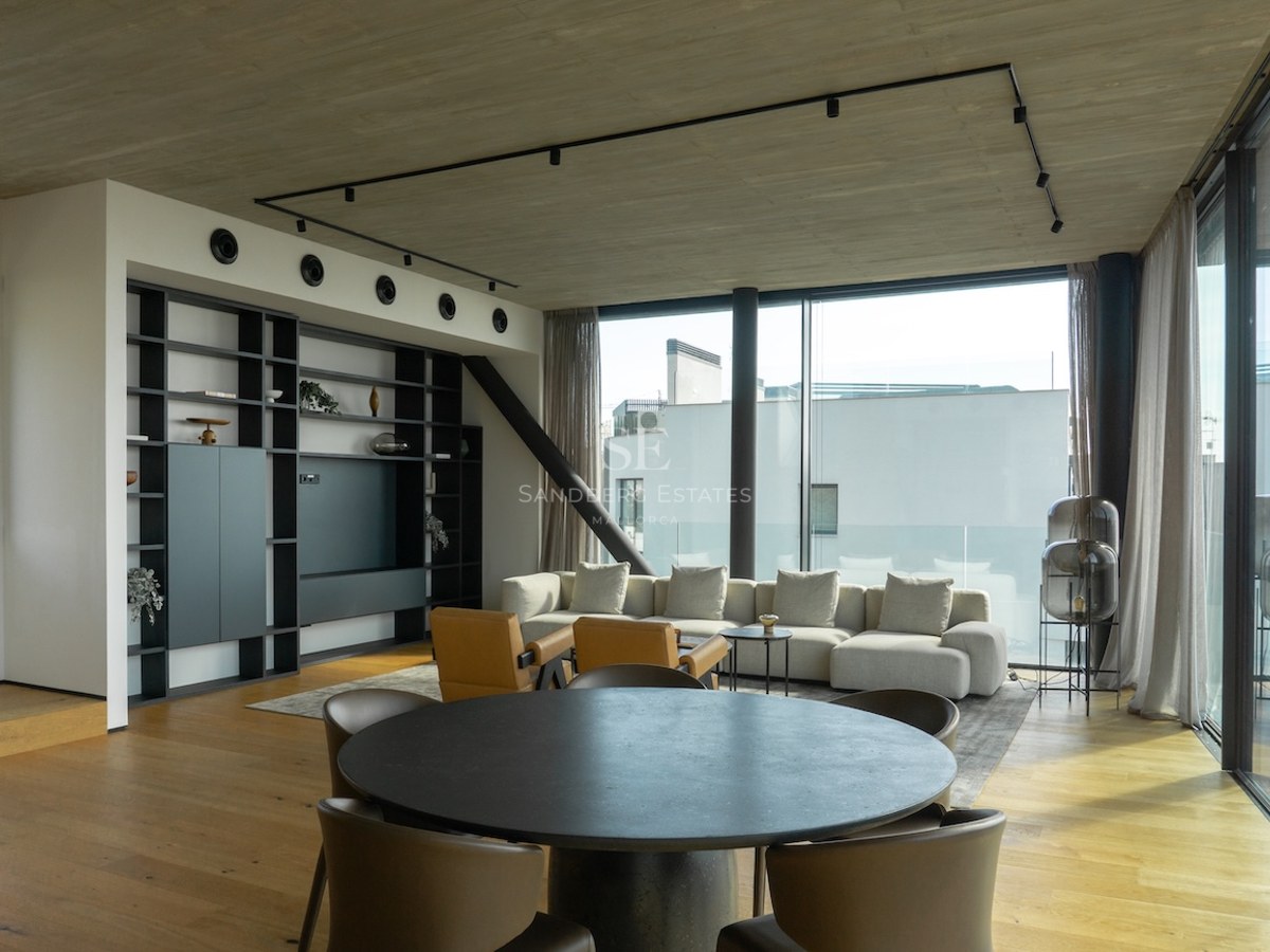 Zeitgenössisches Wohnzimmer mit bodentiefen Fenstern, Eichenparkett und Sichtbetondecke in einer Luxusimmobilie.