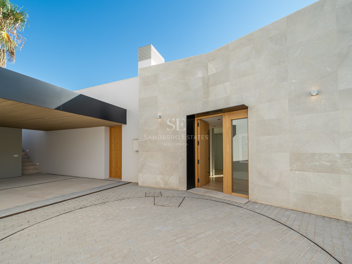 View of an elegant villa with pool, lush gardens, and modern architecture. Abundant natural light.
