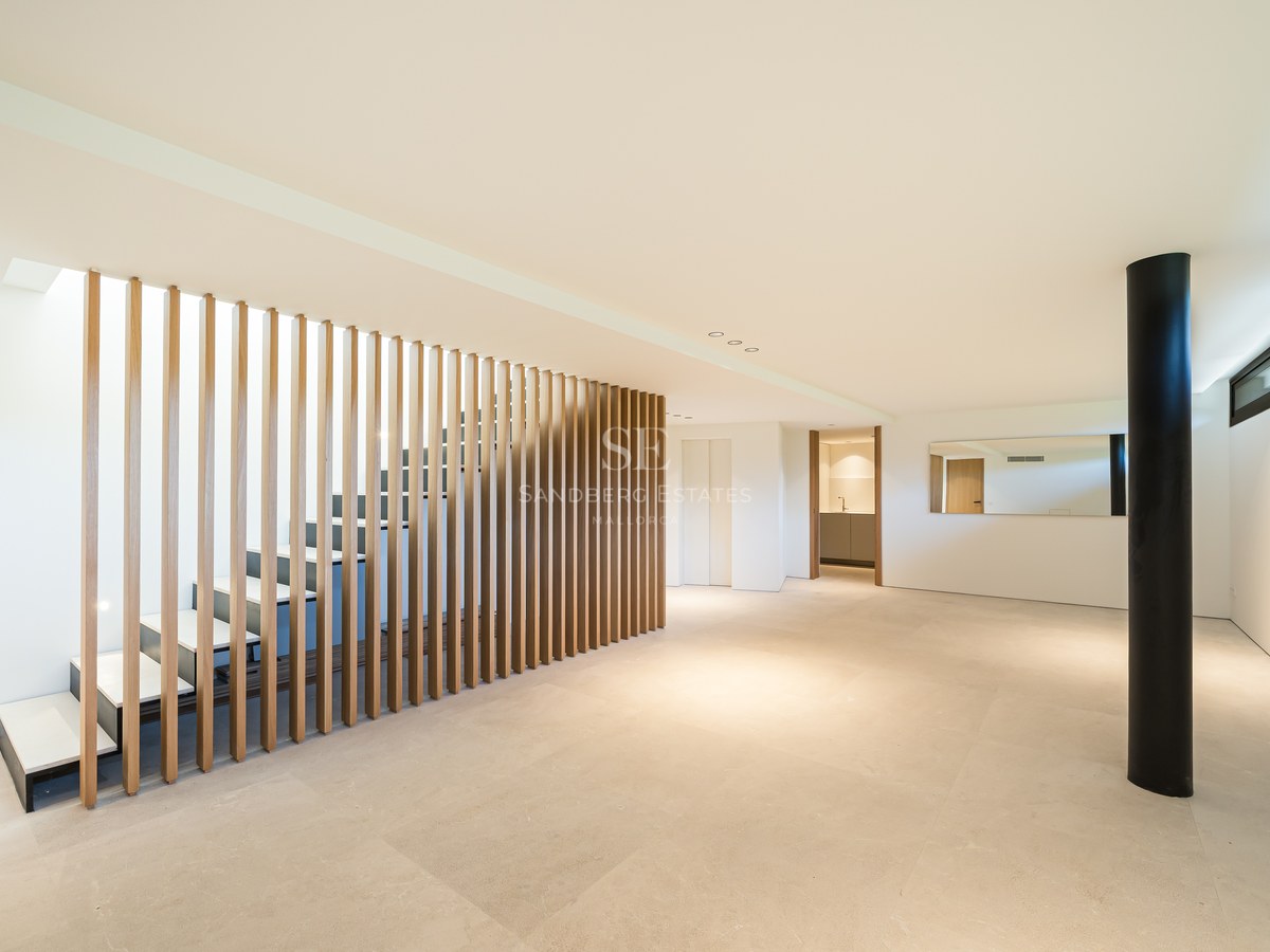 Spacious exterior with swimming pool, outdoor lounge area, sunbeds, and lush greenery. Modern and elegant design.