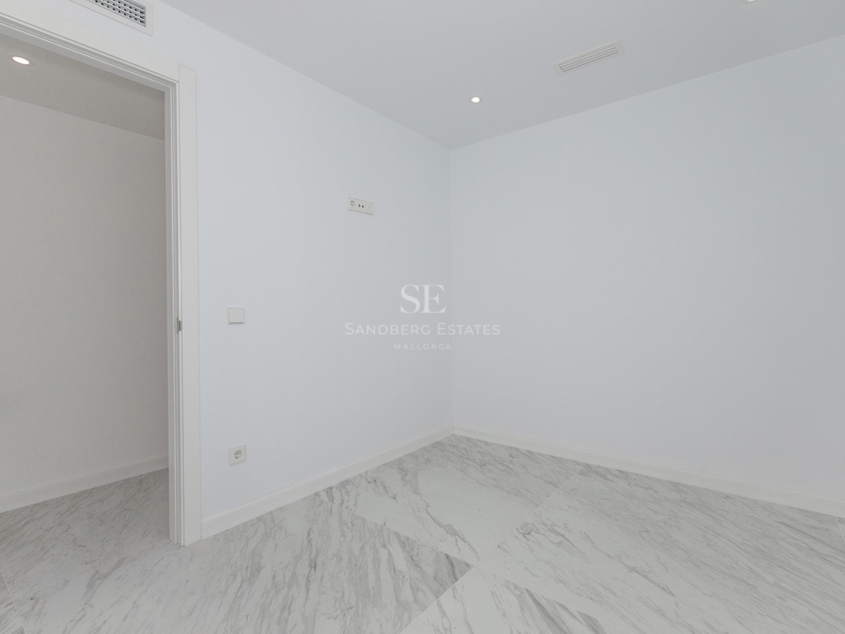 Empty modern room featuring white walls and large-format white marble floor tiles with grey veining.