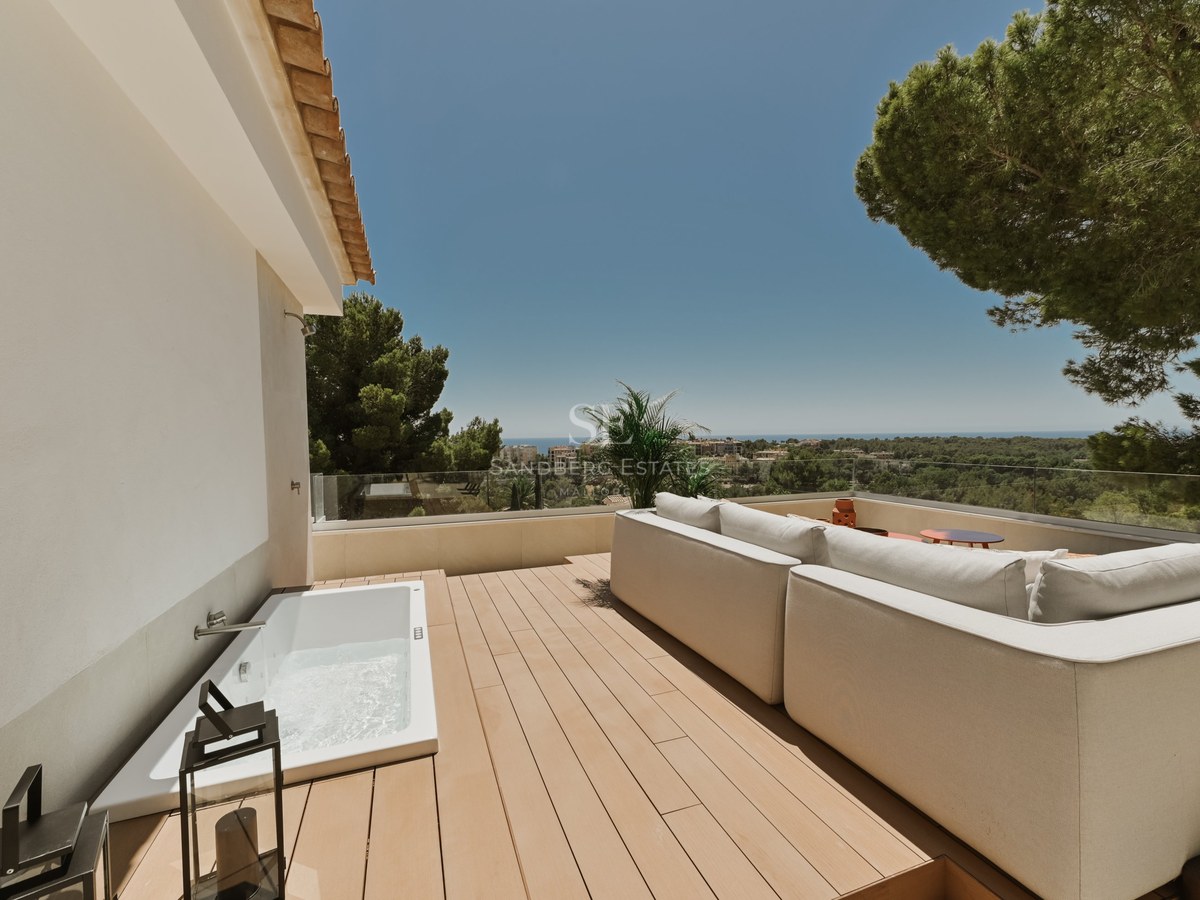 Terraza contemporánea con tarima de madera, piscina de inmersión, sofás de diseño y vistas panorámicas al mar.