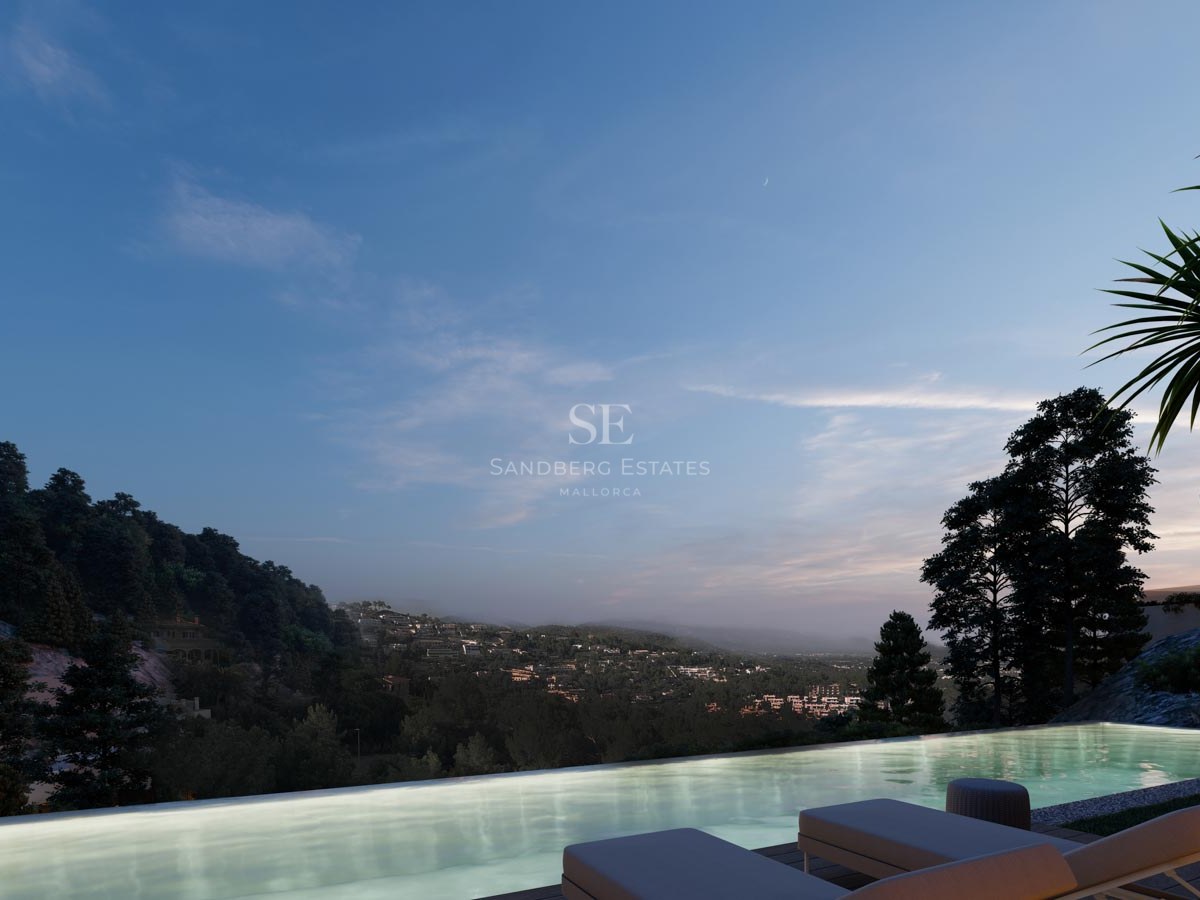Una piscina infinita iluminada con vistas a un valle boscoso y colinas distantes al atardecer con tumbonas.