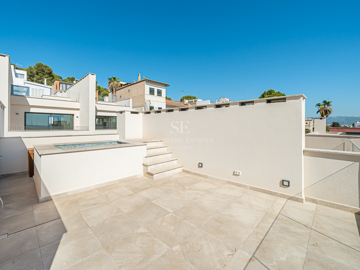 Terraza en azotea con suelo de piedra clara, pequeña piscina elevada, barandillas de cristal y ducha exterior.