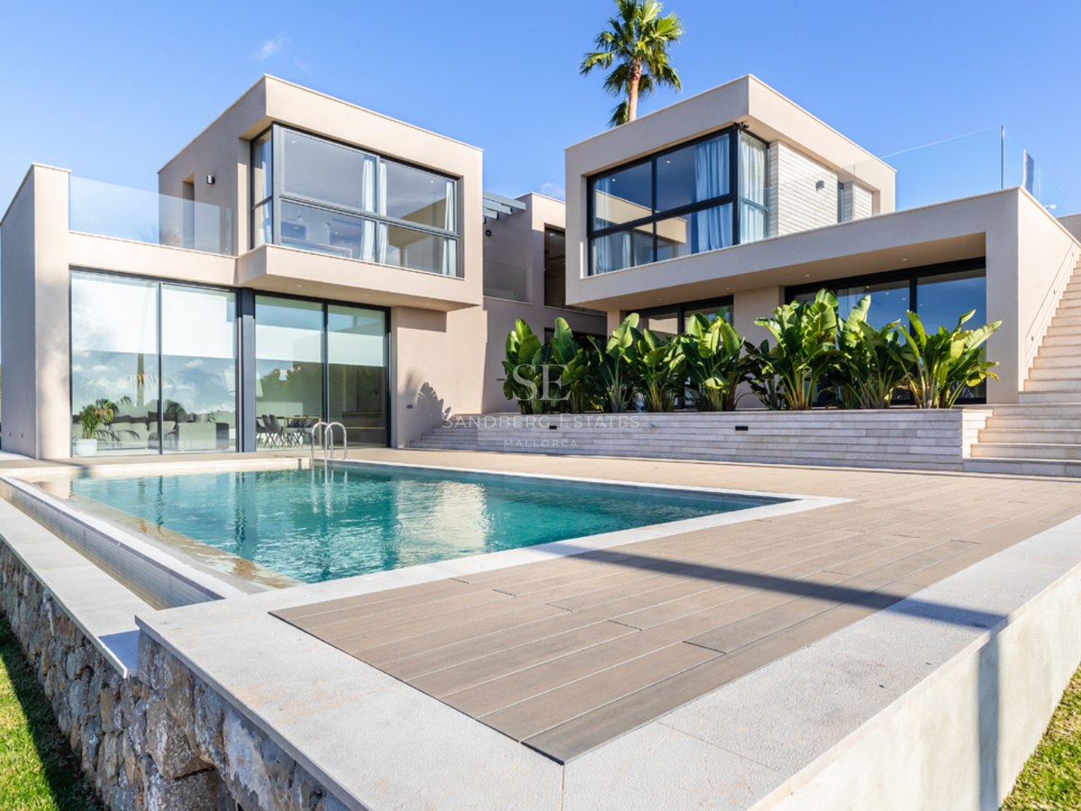 Villa contemporaine couleur sable avec piscine rectangulaire, garde-corps en verre et baies vitrées.