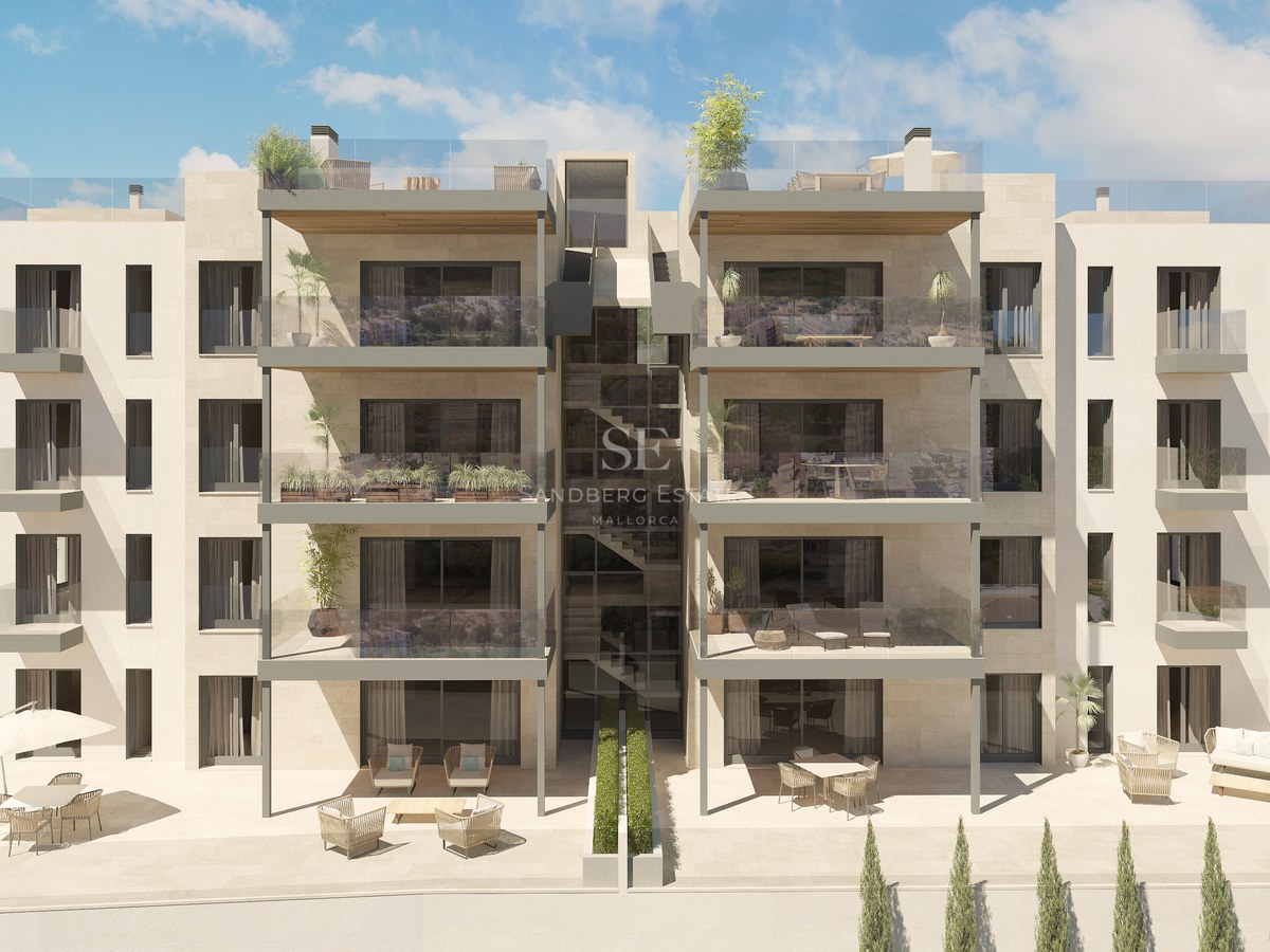 Immeuble résidentiel moderne avec parement en pierre, balcons en verre et grandes baies vitrées.