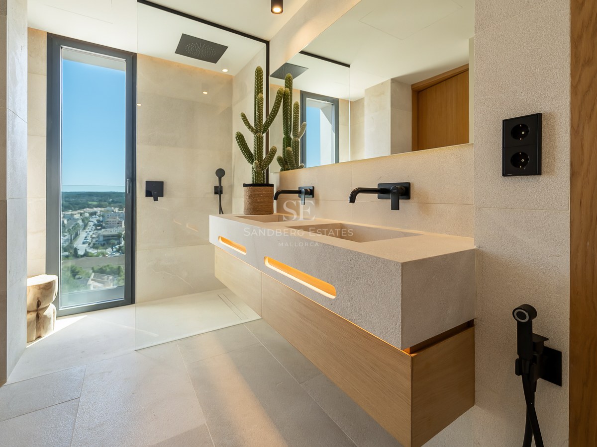 Salle de bains moderne avec double vasque en pierre, robinetterie noir mat, douche à l'italienne et grande fenêtre.