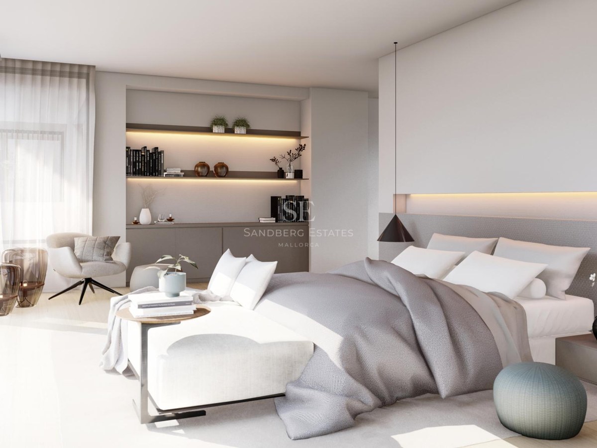 Modern master bedroom with grey linens, floor-to-ceiling windows, a reading chair, and integrated shelving with warm lights.