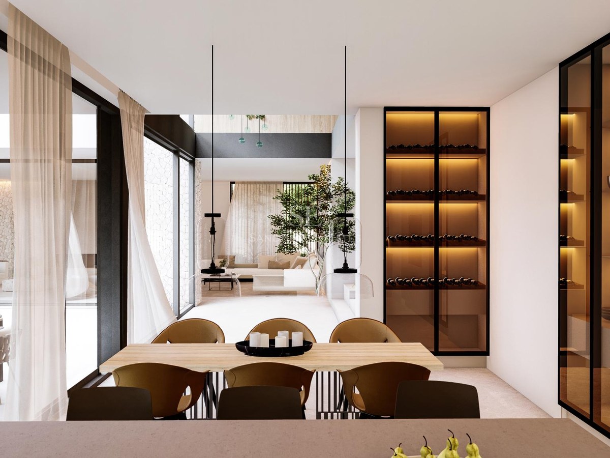 Modern dining room featuring a light wood table, contemporary black chairs, and a glass-fronted illuminated wine cabinet.