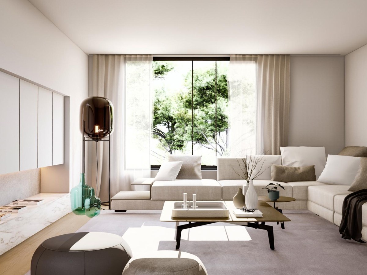 Bright minimalist living room featuring a large modular beige sofa, marble cabinetry, and a view of green trees.