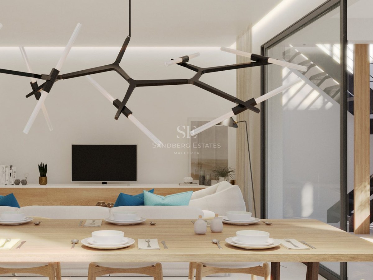 A modern dining room with a large wooden table and designer lighting, opening into a bright living area.