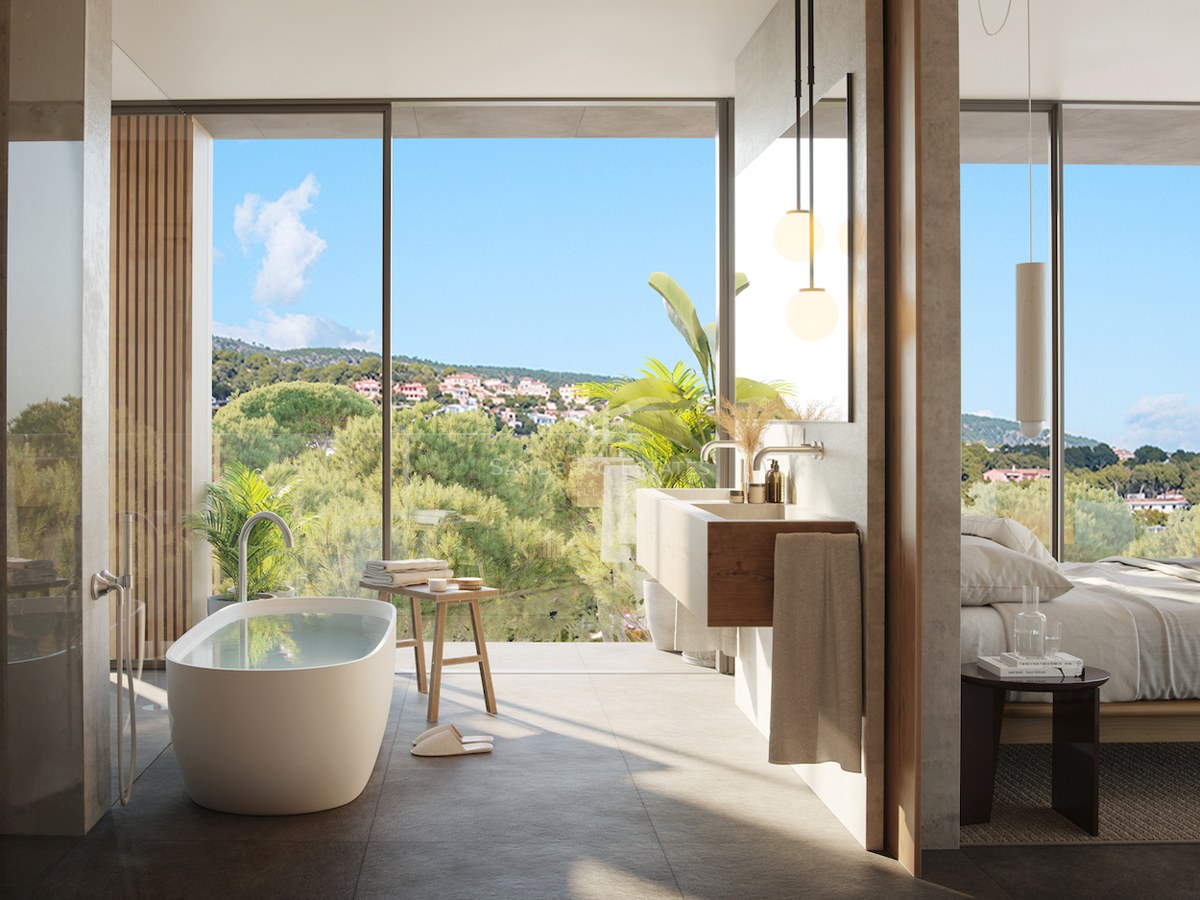 Luxury master bathroom featuring a freestanding tub, floating wood vanity, and floor-to-ceiling windows with forest views.