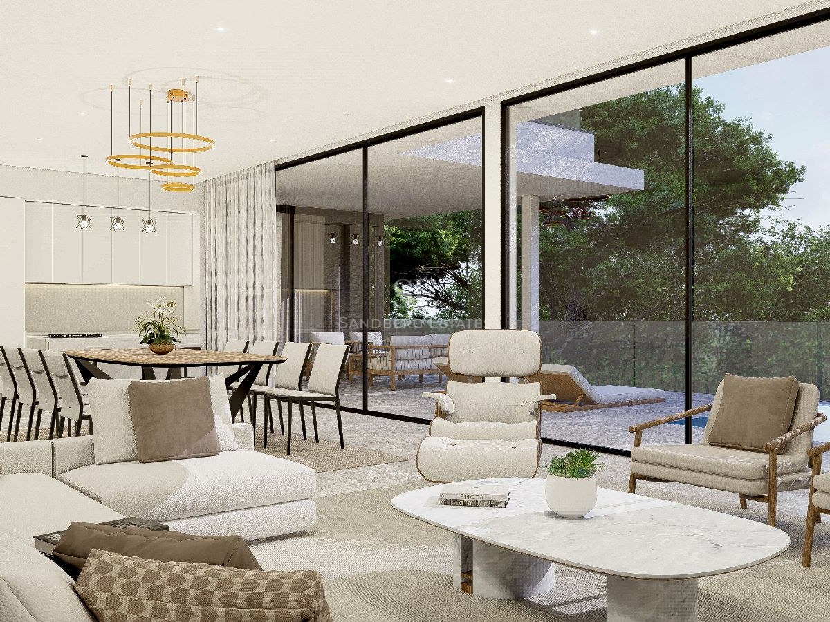 Salón moderno con sofás crema, mesa de mármol y ventanales de suelo a techo con vistas a la piscina y jardín.