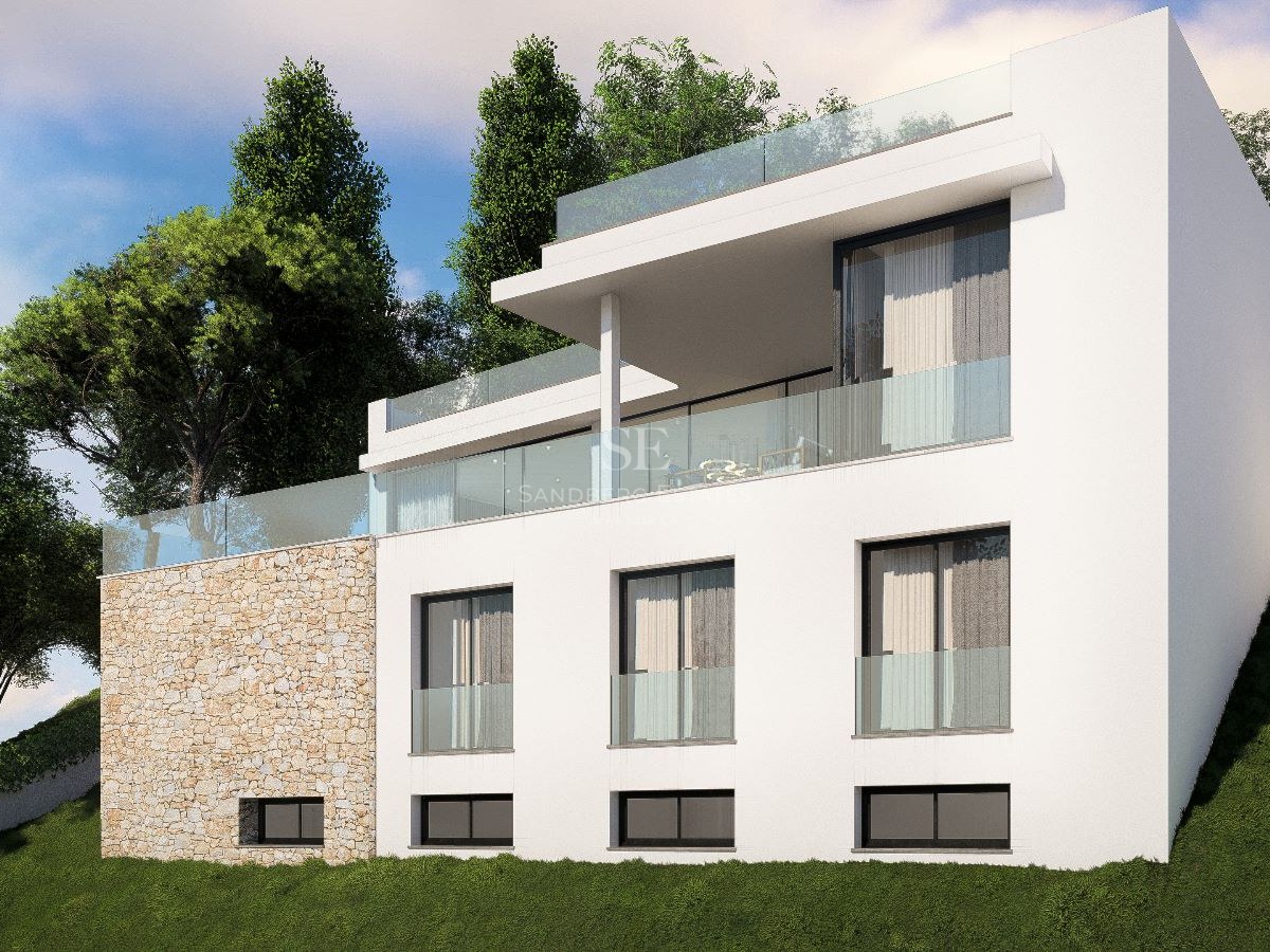 Villa moderna de tres niveles con barandillas de cristal y muros de piedra natural en una ladera verde.