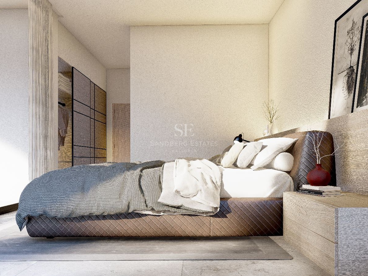 Dormitorio principal moderno con cama acolchada, mesita de noche de madera integrada y grandes ventanales.