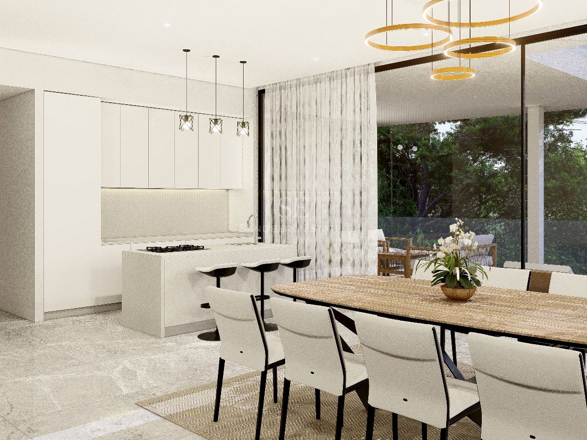 Comedor moderno con mesa de madera y sillas blancas frente a una cocina minimalista con acceso a la terraza.