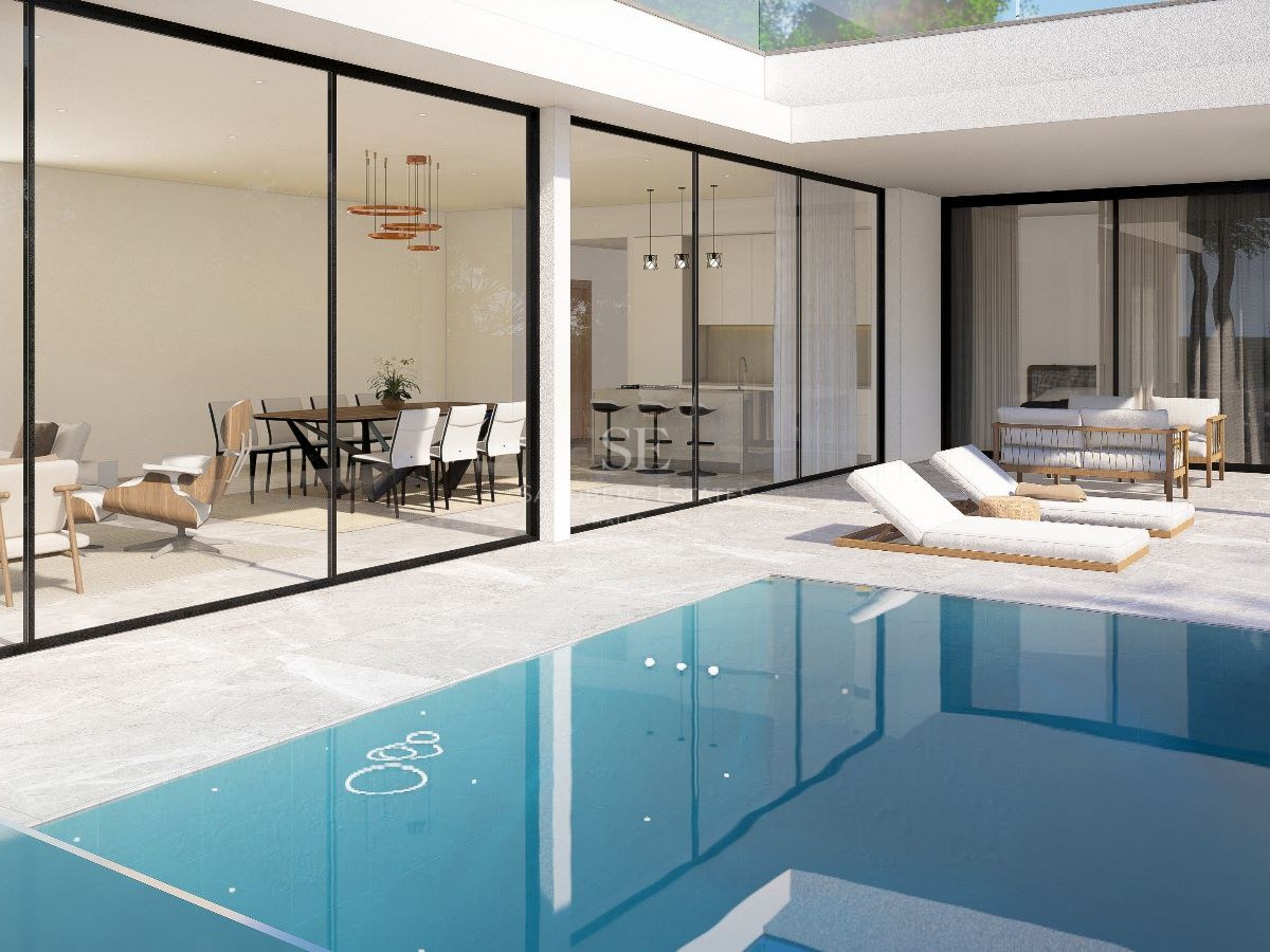 Terraza de villa contemporánea de lujo con piscina turquesa, tumbonas y paredes de cristal de suelo a techo.