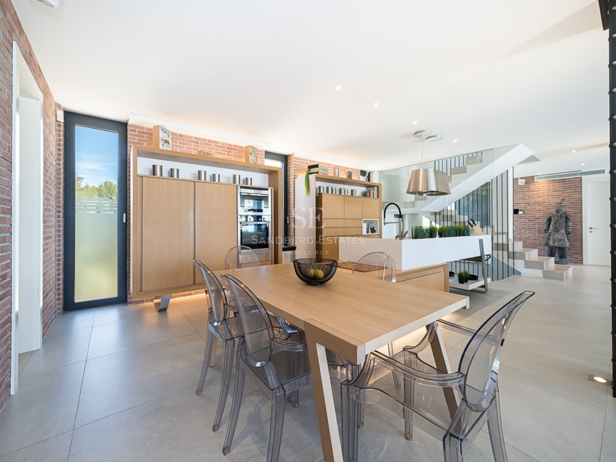 Vue panoramique d'un balcon luxueux avec piscine à débordement et vue sur la mer. Design moderne avec mobilier élégant et végétation luxuriante.