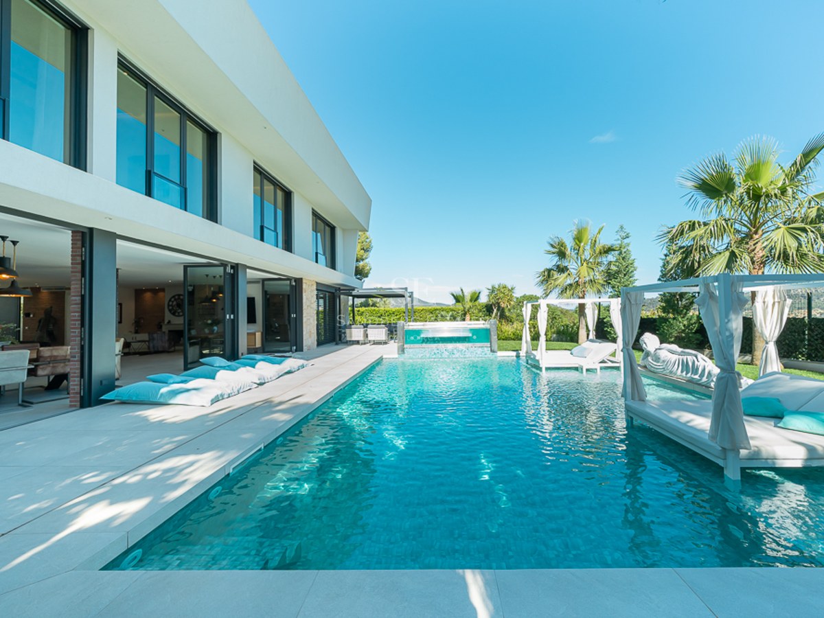 Vue extérieure d'une villa moderne avec piscine, jardin et vastes terrasses. Design élégant et finitions de haute qualité.