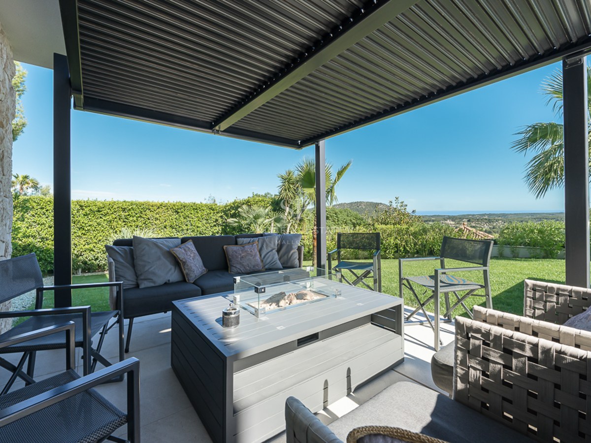 Grand balcon offrant une vue panoramique sur la mer. Design moderne, minimaliste avec garde-corps en verre et mobilier d'extérieur.