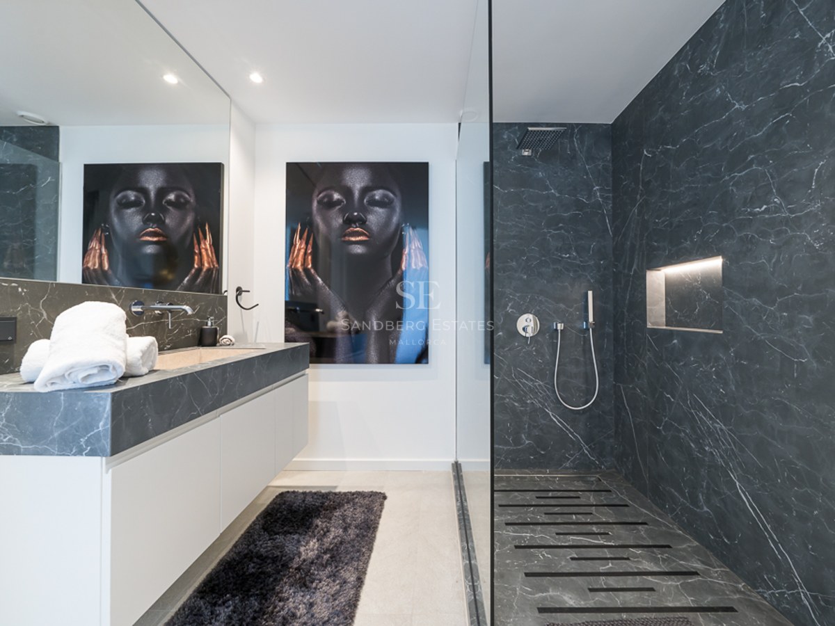 Salon spacieux avec cheminée, canapés beiges, grandes fenêtres donnant sur le jardin et abondance de lumière naturelle. Design moderne et élégant.