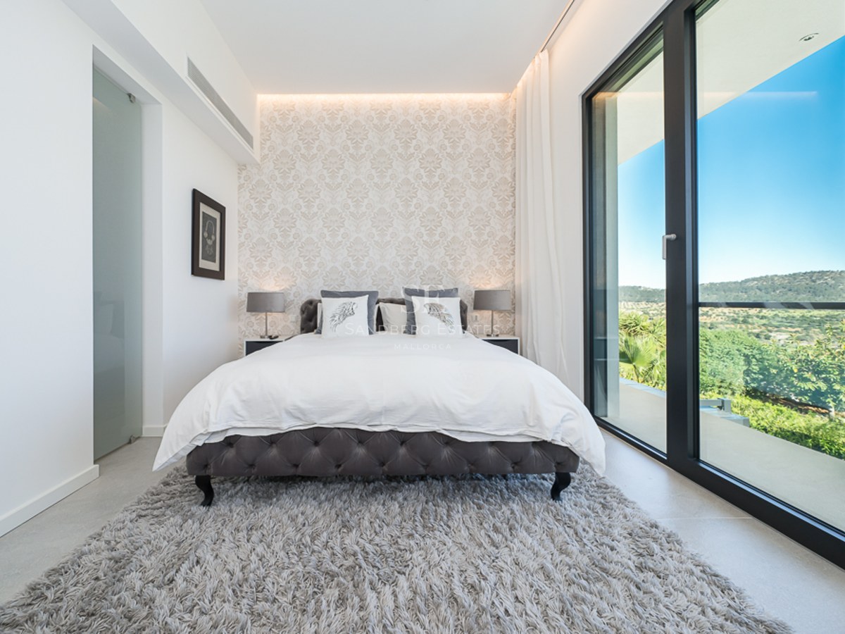 Vaste salon avec de grandes baies vitrées, parquet clair, lumière naturelle et décoration minimaliste. Vue sur un jardin luxuriant.