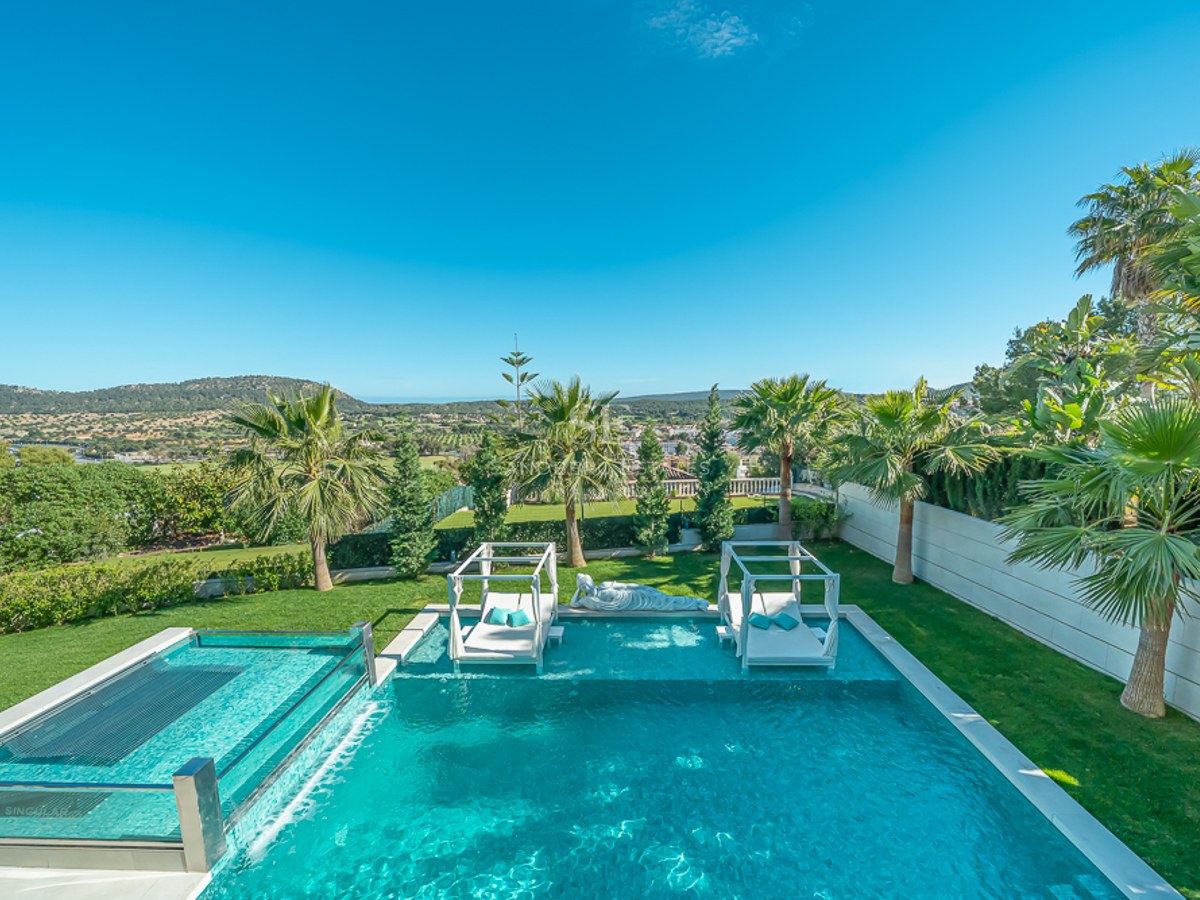 Grand balcon avec vue sur la mer. Mobilier d'extérieur élégant avec fauteuils et table basse. Garde-corps en verre maximisant la vue panoramique.