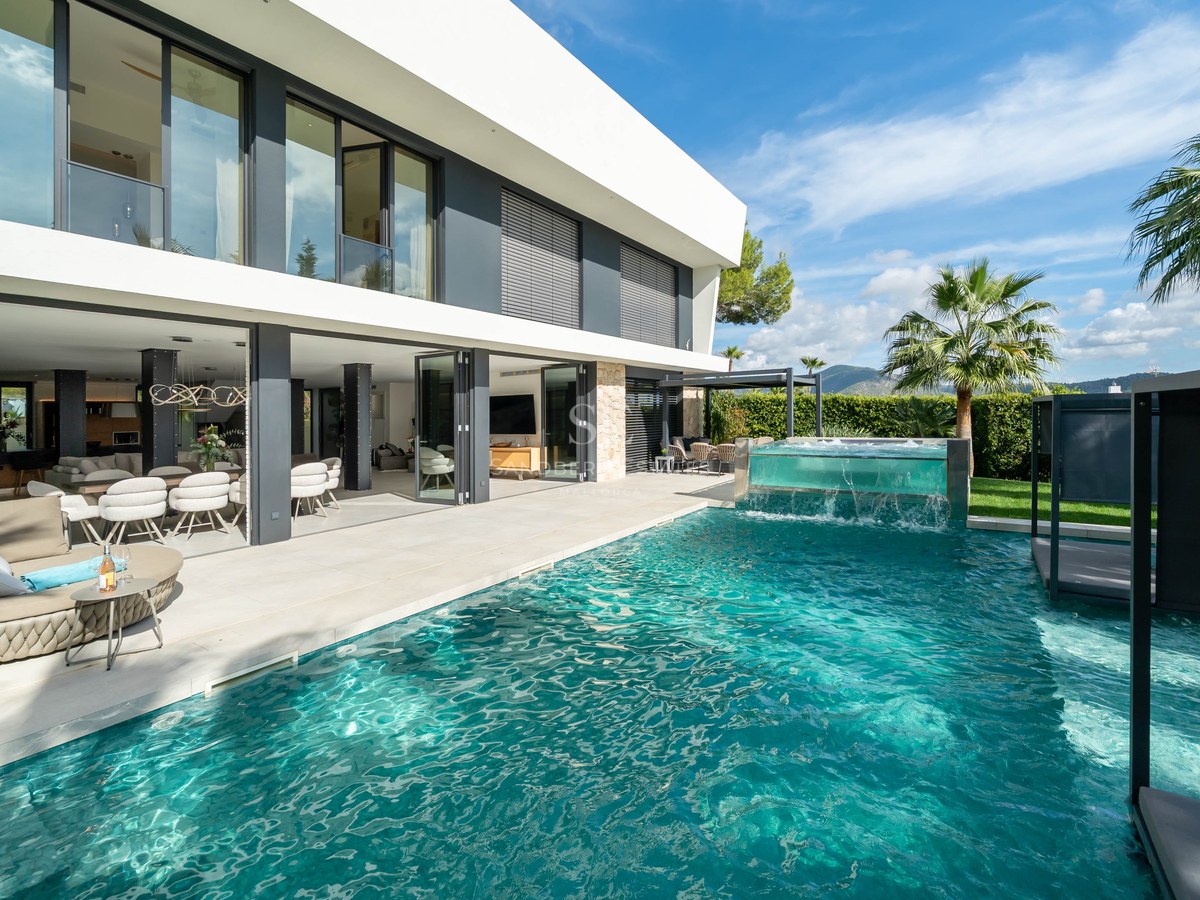 Villa de luxe avec piscine turquoise, jacuzzi aux parois en verre et terrasse ouverte sous un ciel bleu.