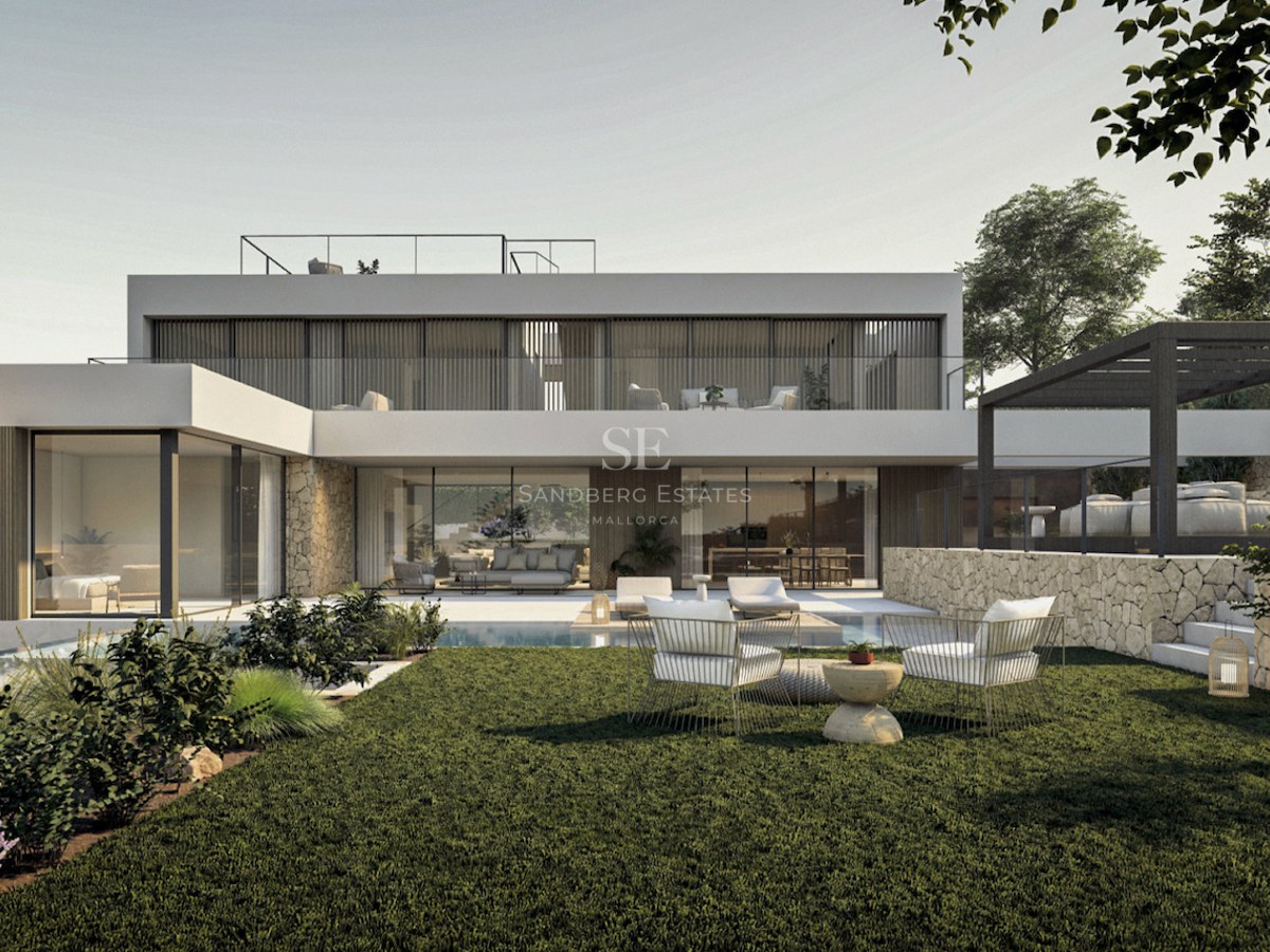 Vue extérieure d'une villa moderne blanche avec murs en pierre, grandes baies vitrées et pelouse verte.
