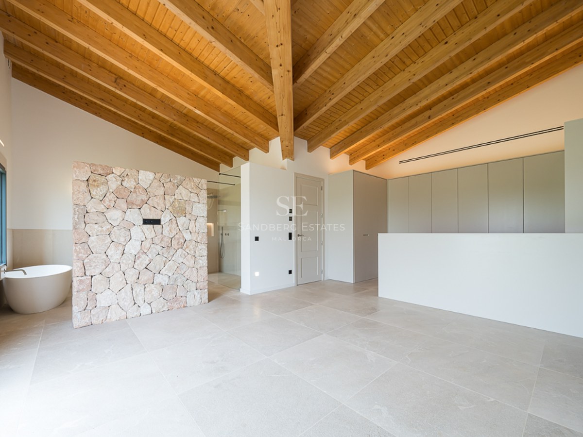 Modernes Badezimmer mit gewölbter Holzdecke, Natursteinwand und freistehender ovaler Badewanne.