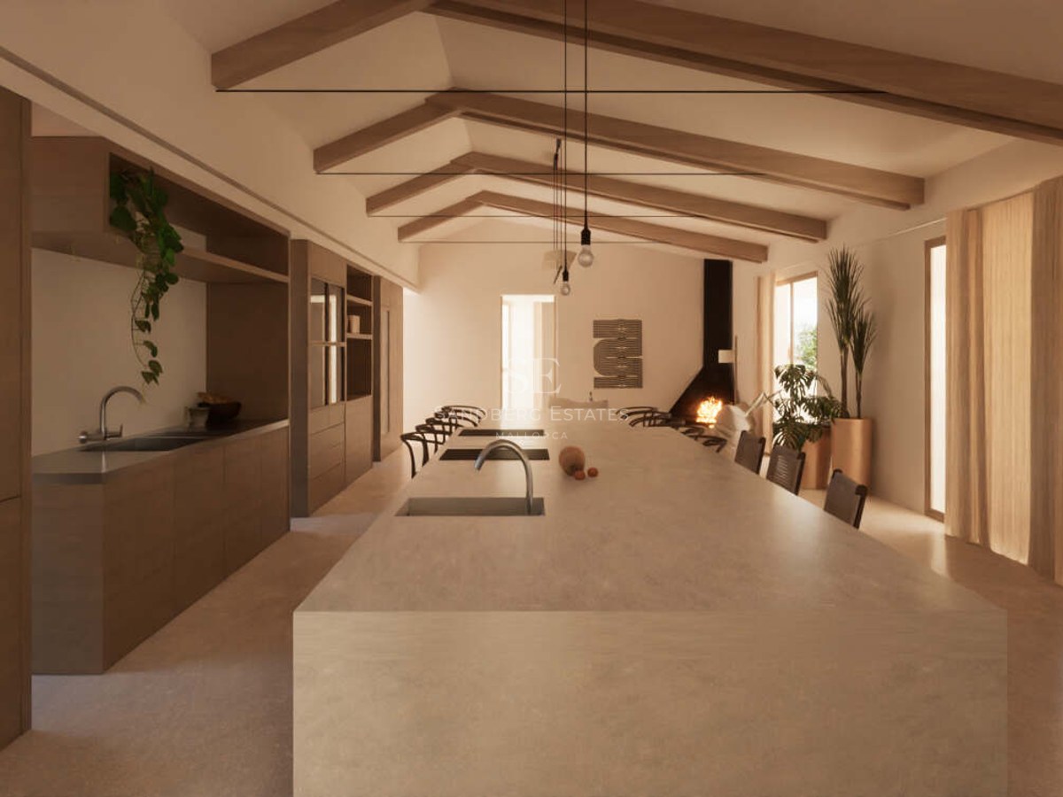 Minimalist kitchen featuring a large stone island, exposed wooden beams, and a fireplace in an open-plan living space.
