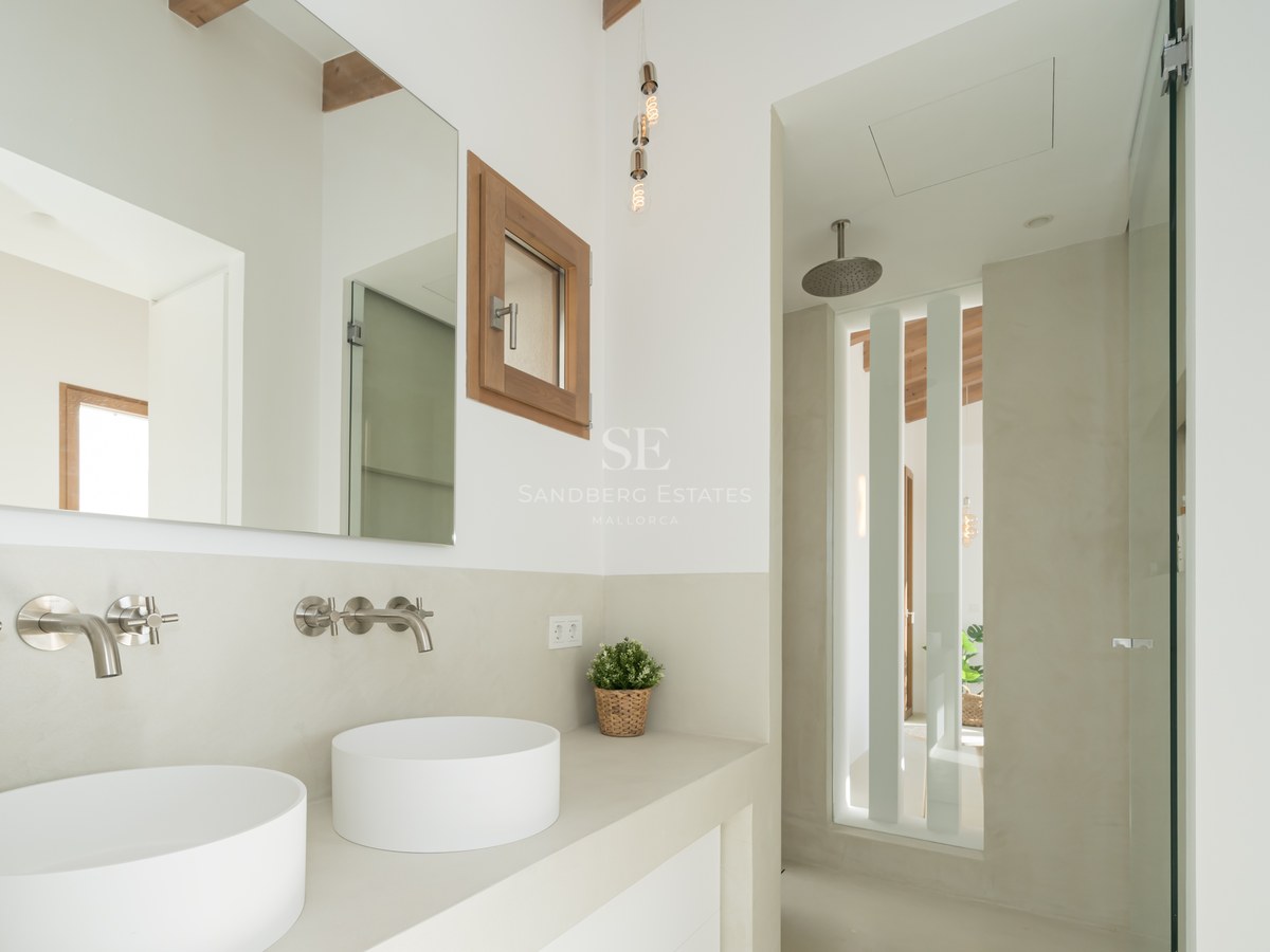 Contemporary bathroom featuring two vessel sinks, wall-mounted chrome faucets, and a walk-in rain shower.