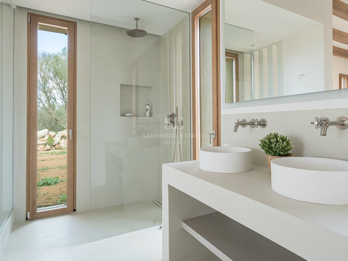 Contemporary bathroom featuring double vessel sinks, a walk-in glass shower, and light wood window frames.