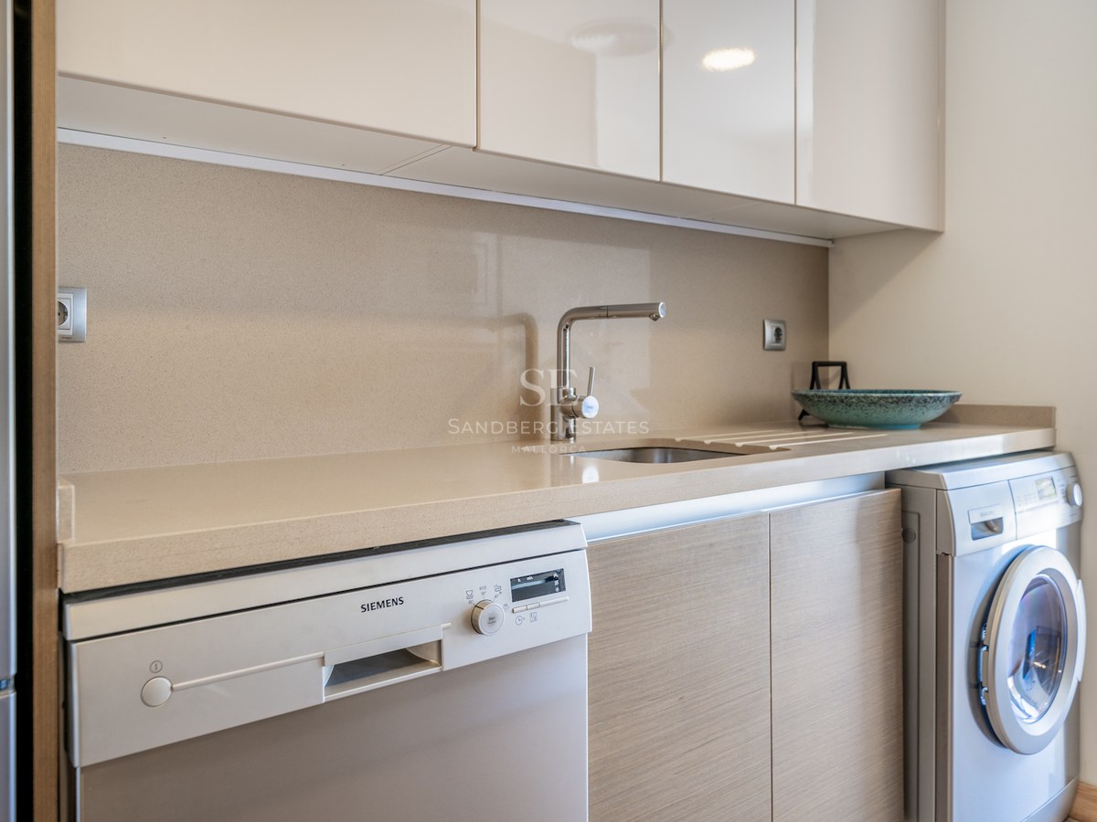 Modern utility area featuring a quartz countertop, stainless steel sink, and integrated Siemens appliances.