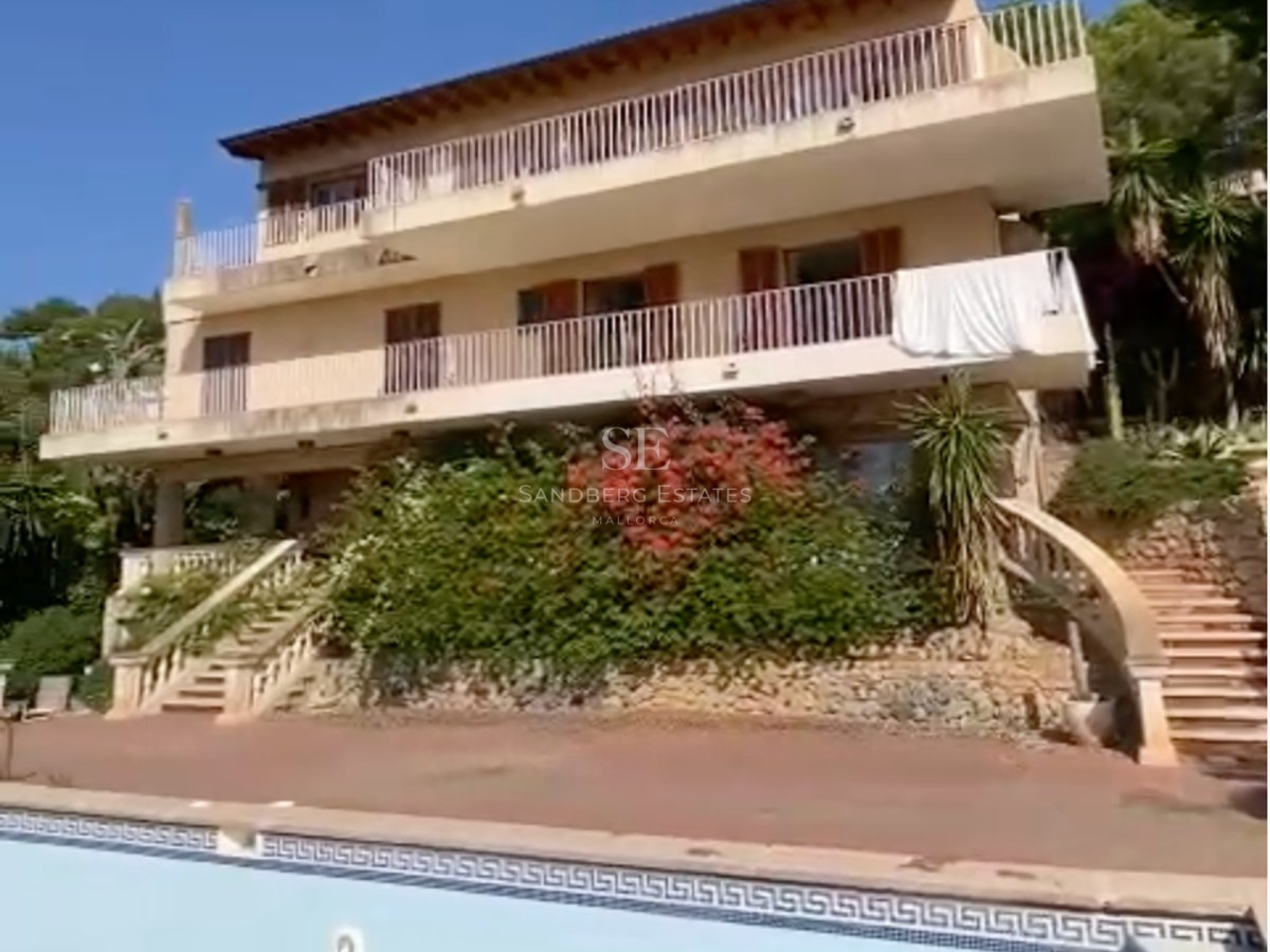 Vista exterior de una villa mediterránea de tres plantas con piscina, terrazas a varios niveles y escaleras de piedra.