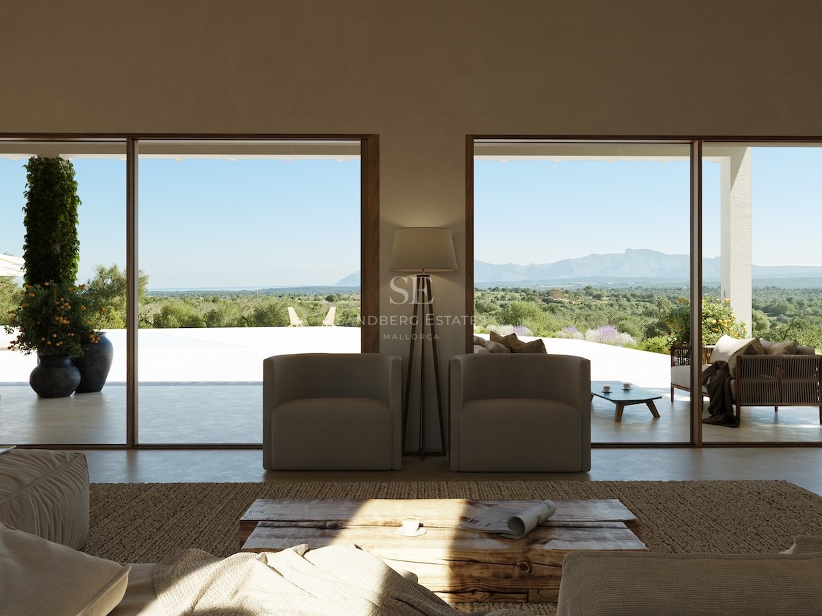 Minimalistisches Wohnzimmer mit bodentiefer Verglasung zur Terrasse mit weitem Blick über das Tal und die Berge.