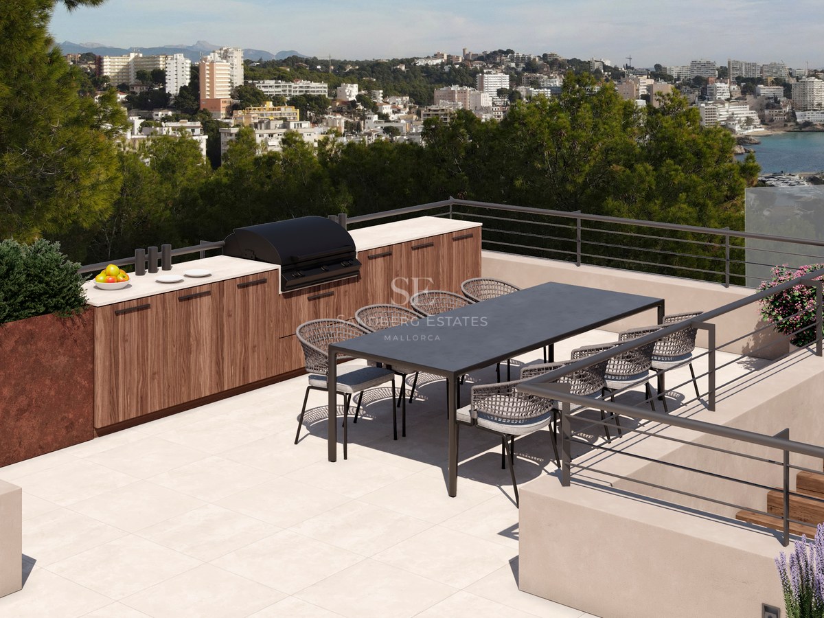 Toit-terrasse moderne avec cuisine extérieure, table pour huit et vue panoramique sur la côte.