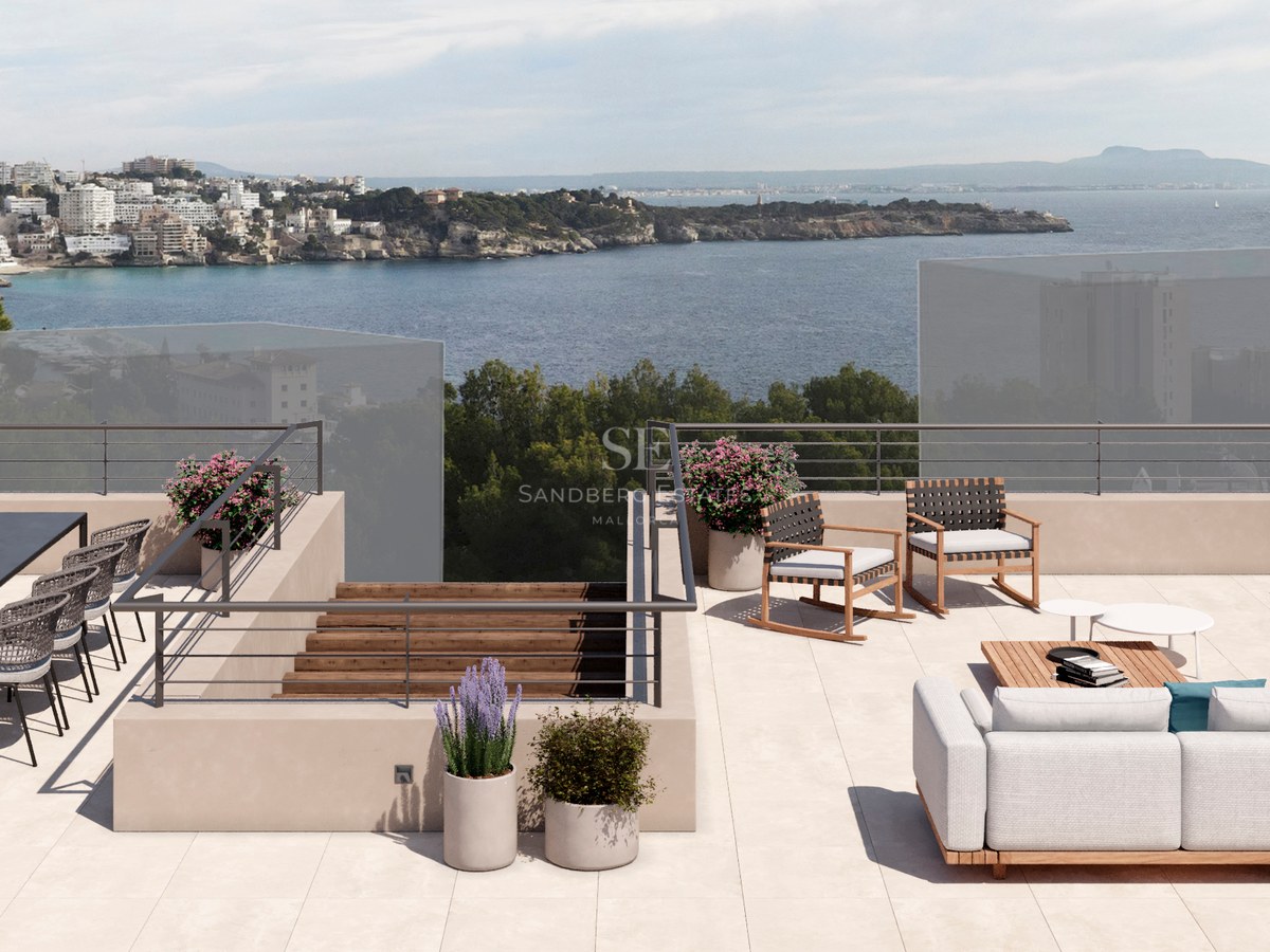 Vaste toit-terrasse avec cuisine d'été, coin repas et salon offrant une vue imprenable sur la mer.