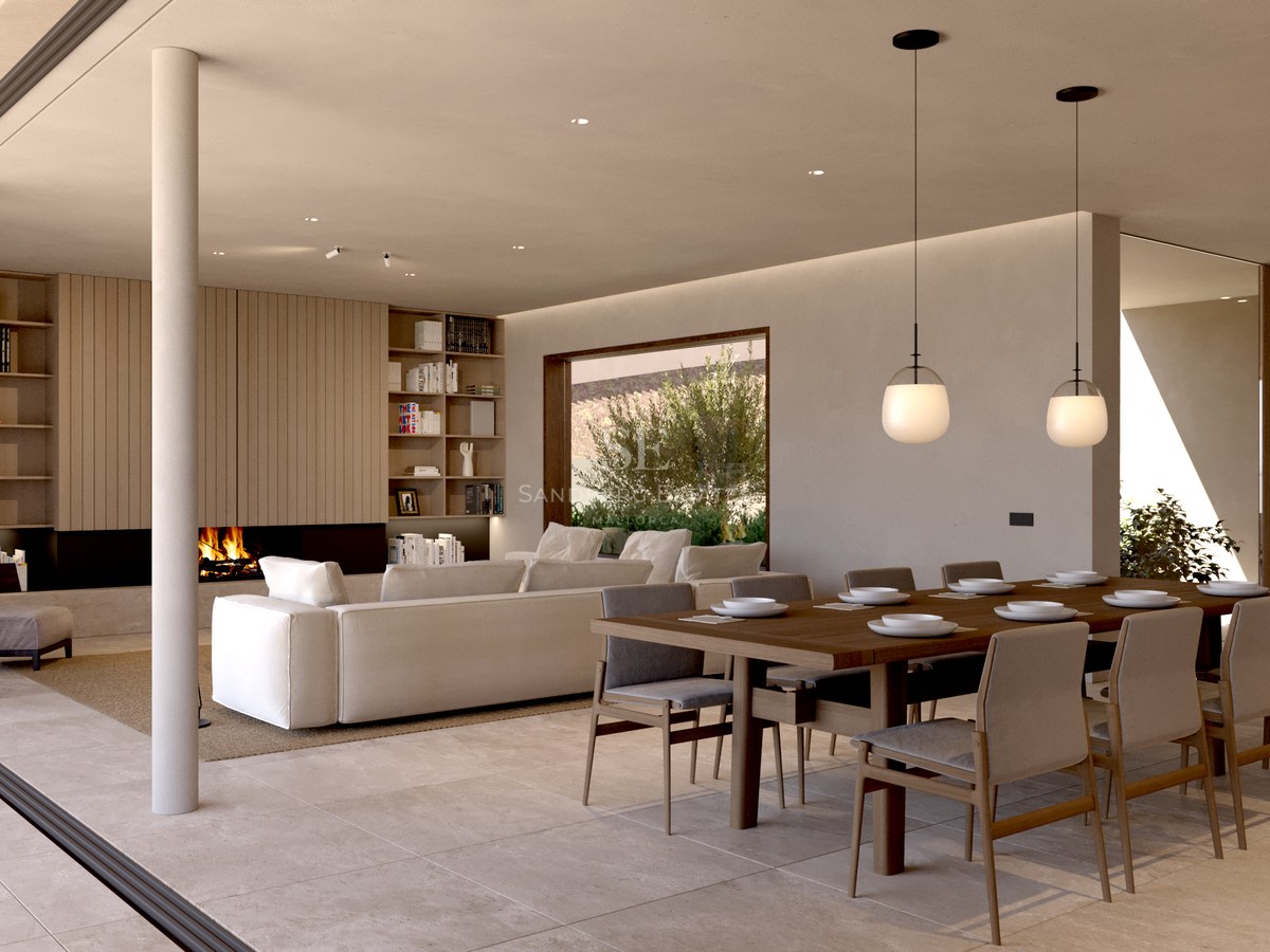 Salon et salle à manger modernes avec sol en pierre naturelle, grandes baies vitrées et cheminée intégrée.