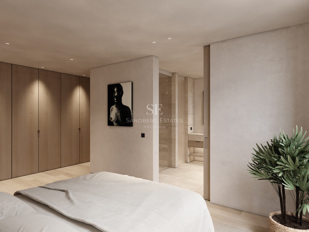 Chambre moderne avec placards en bois, murs beiges et vue sur une salle de bain privée aux finitions en pierre.