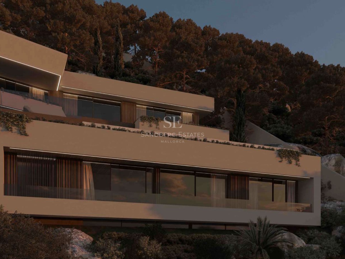 Villa contemporánea de varios niveles con terrazas de cristal integrada en una colina de pinos al anochecer.