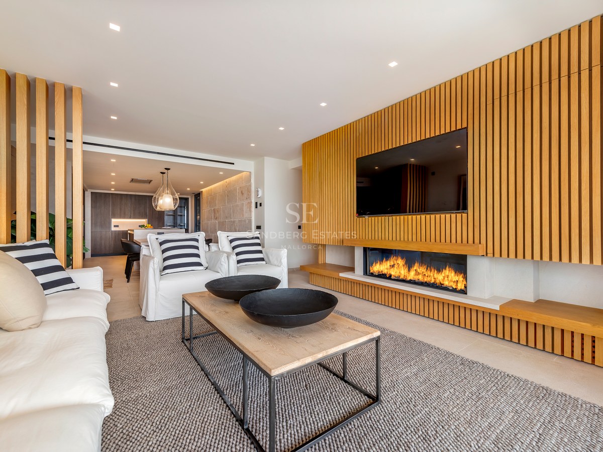 Salón contemporáneo con pared de listones de roble, chimenea lineal integrada y sofás blancos.