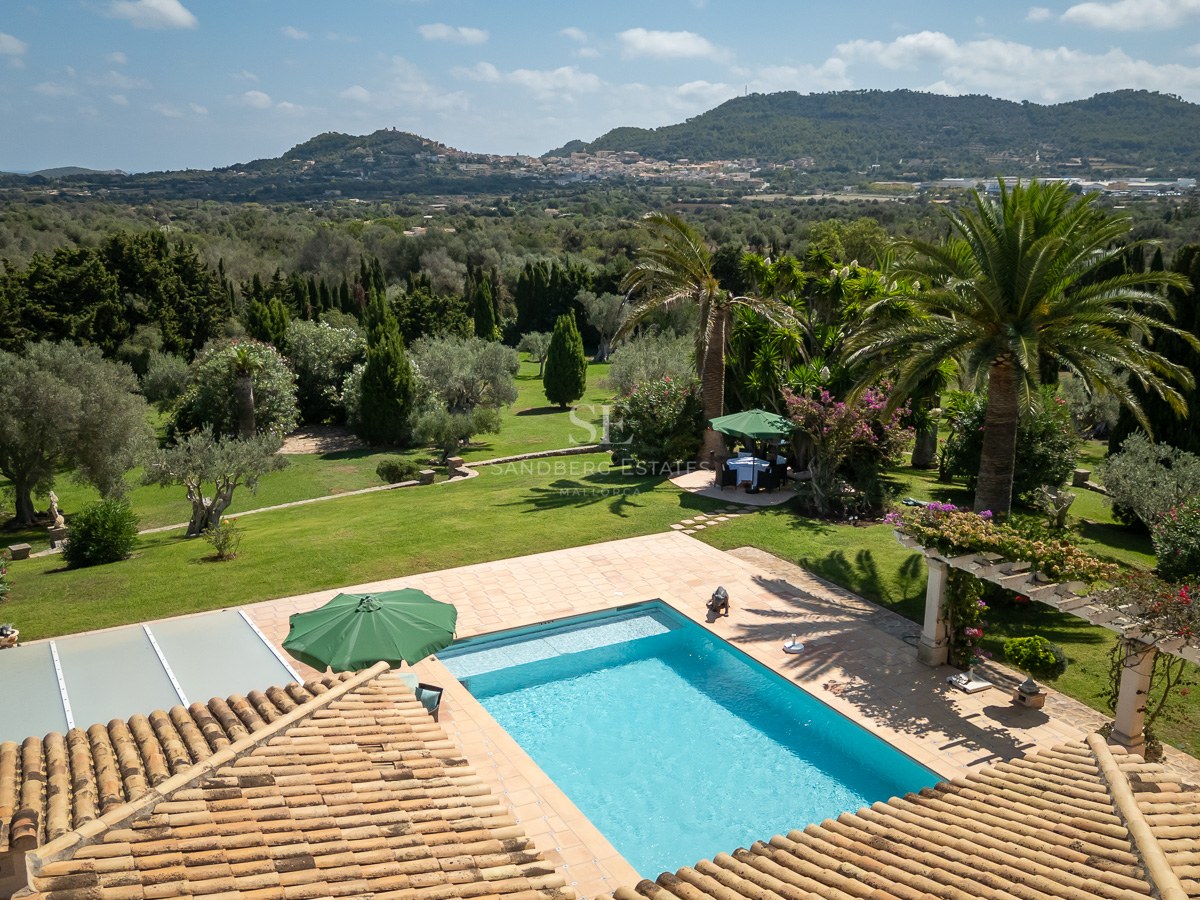 Erhöhte Ansicht eines Pools, umgeben von Terrakotta-Terrassen und üppigen mediterranen Gärten.