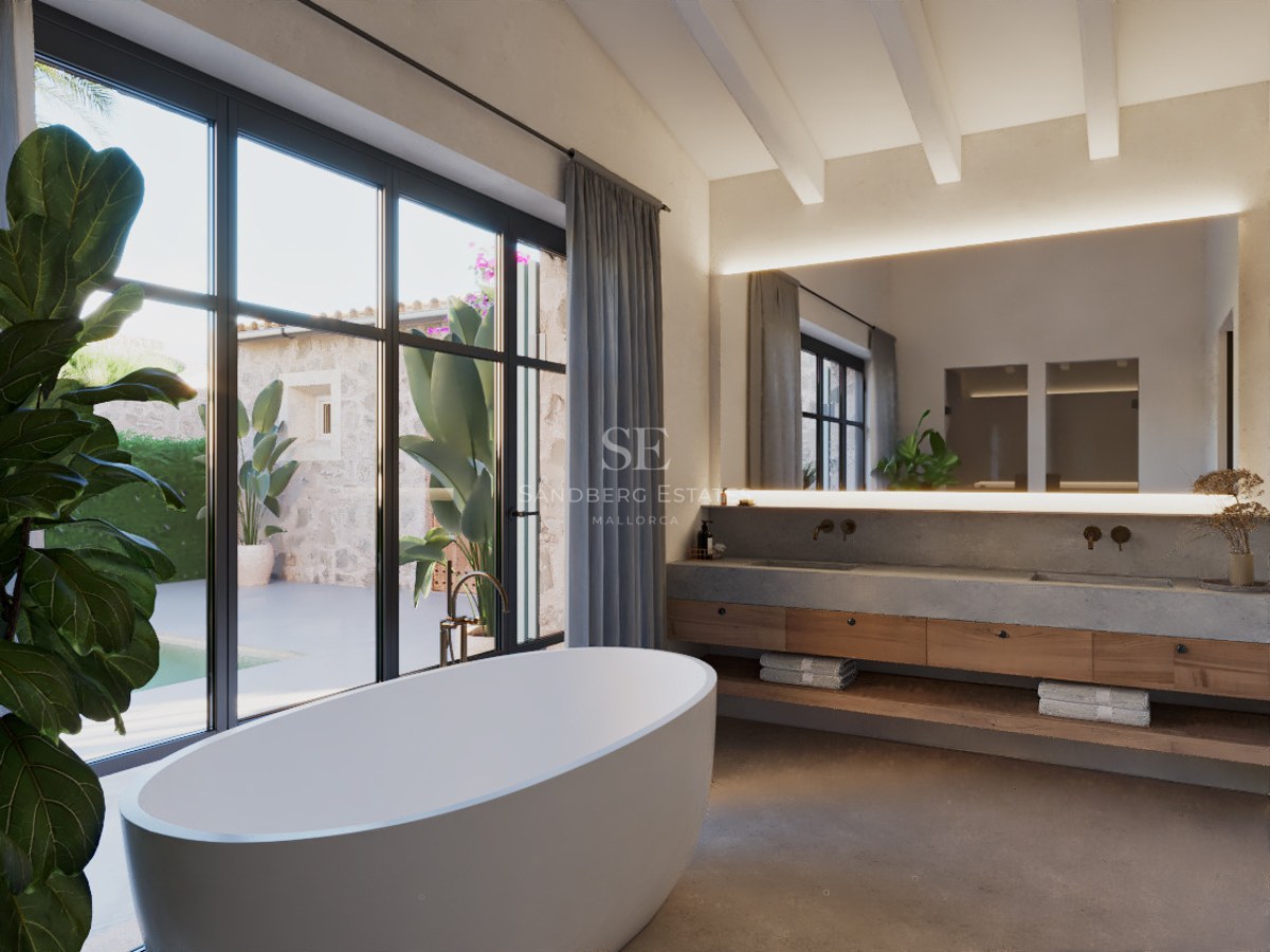Ein minimalistisches Hauptbadezimmer mit freistehender Badewanne, Holz- und Betonwaschtisch und großen Fenstern zum Hof.