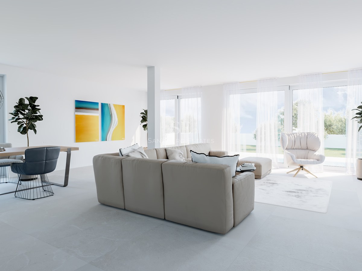 Heller, minimalistischer Wohnbereich mit beigem Sofa, blauen Essstühlen und großen Fenstern zum Garten.
