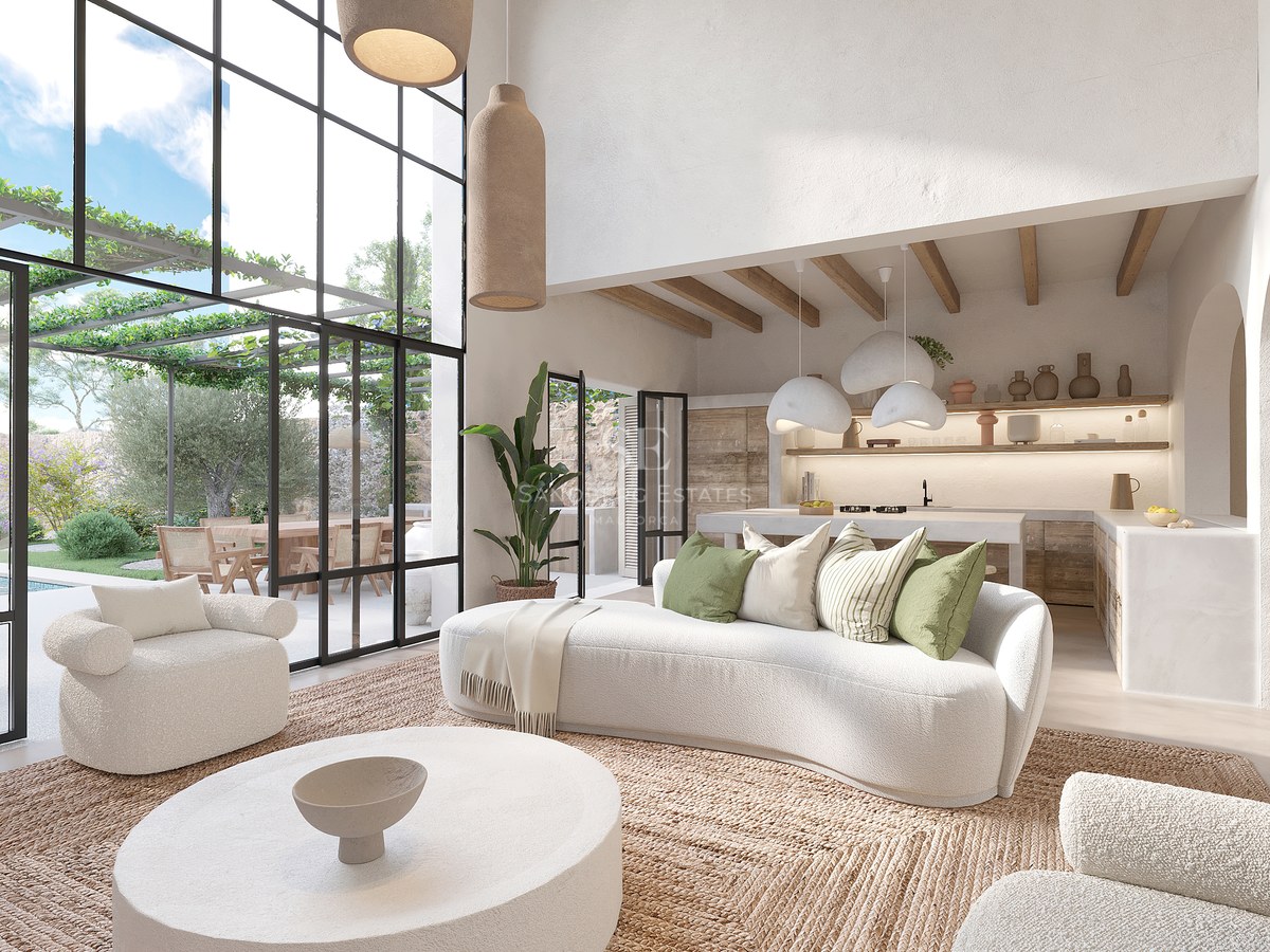 Grand salon blanc avec canapés incurvés, tapis en jute et baies vitrées donnant sur une terrasse verdoyante.
