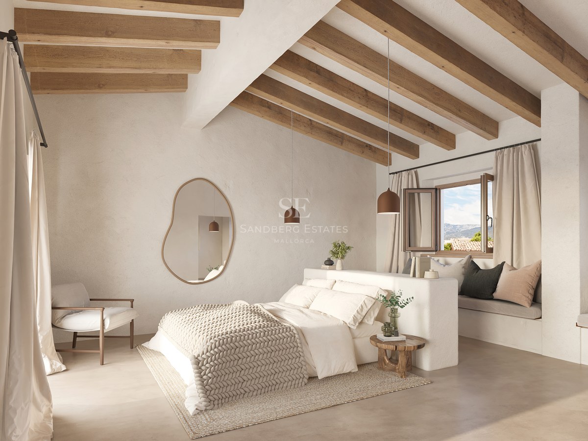 Chambre lumineuse avec hauts plafonds, poutres en bois, grand lit et miroir mural de forme organique.